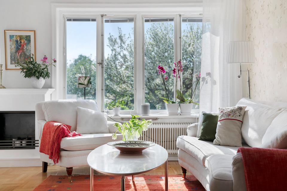 Scandinavian living room featuring soft furnishings, natural light, and decorative plants, highlighting Swedish design aesthetics.