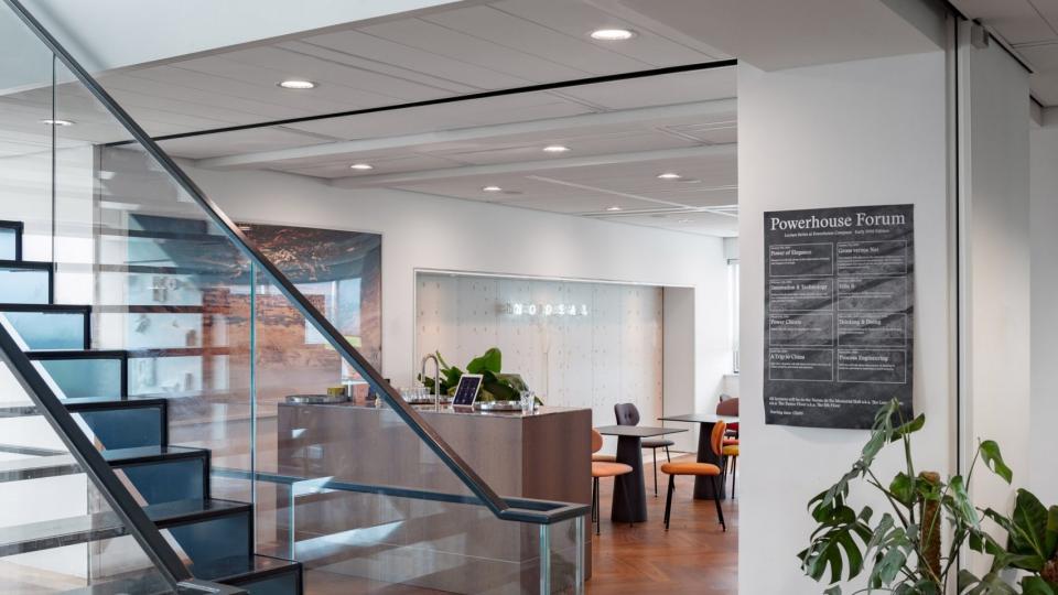 Modern architect's studio interior featuring sleek stairs, a workspace, and creative displays, highlighting Dutch design aesthetics.