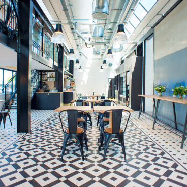 Industrial-style interior featuring Karndean Heritage Collection Flooring, with stylish seating and ample natural light.
