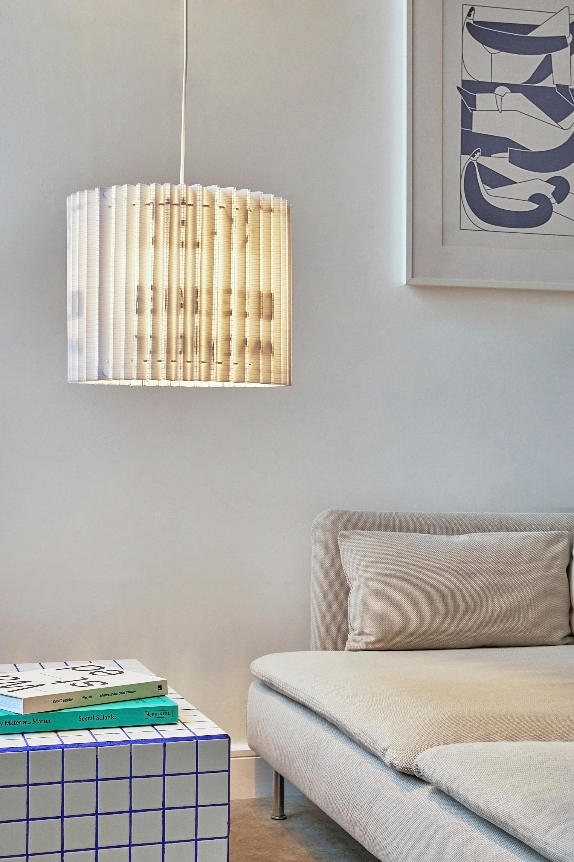 Sustainable sculptural lampshade by Tabitha Bargh illuminating a modern living space with a stylish coffee table.
