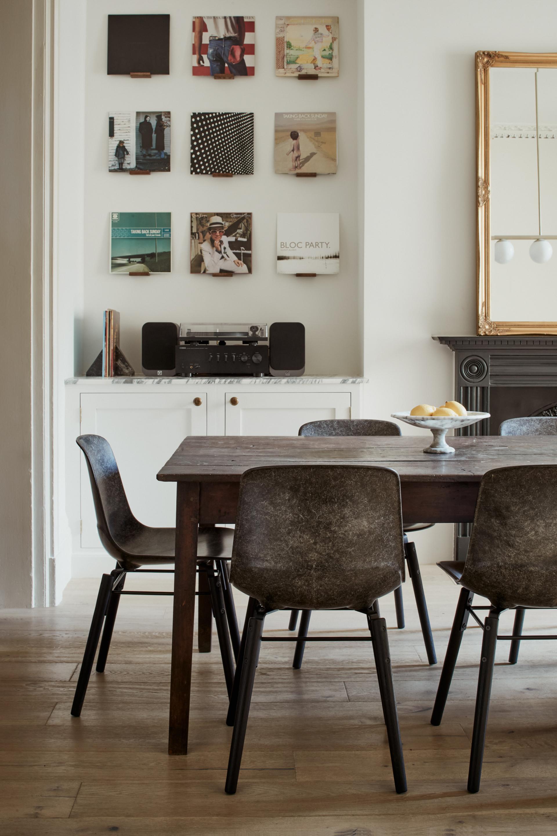 Stylish dining area featuring Solidwool's sustainable furniture and vintage vinyl records displayed on the wall.