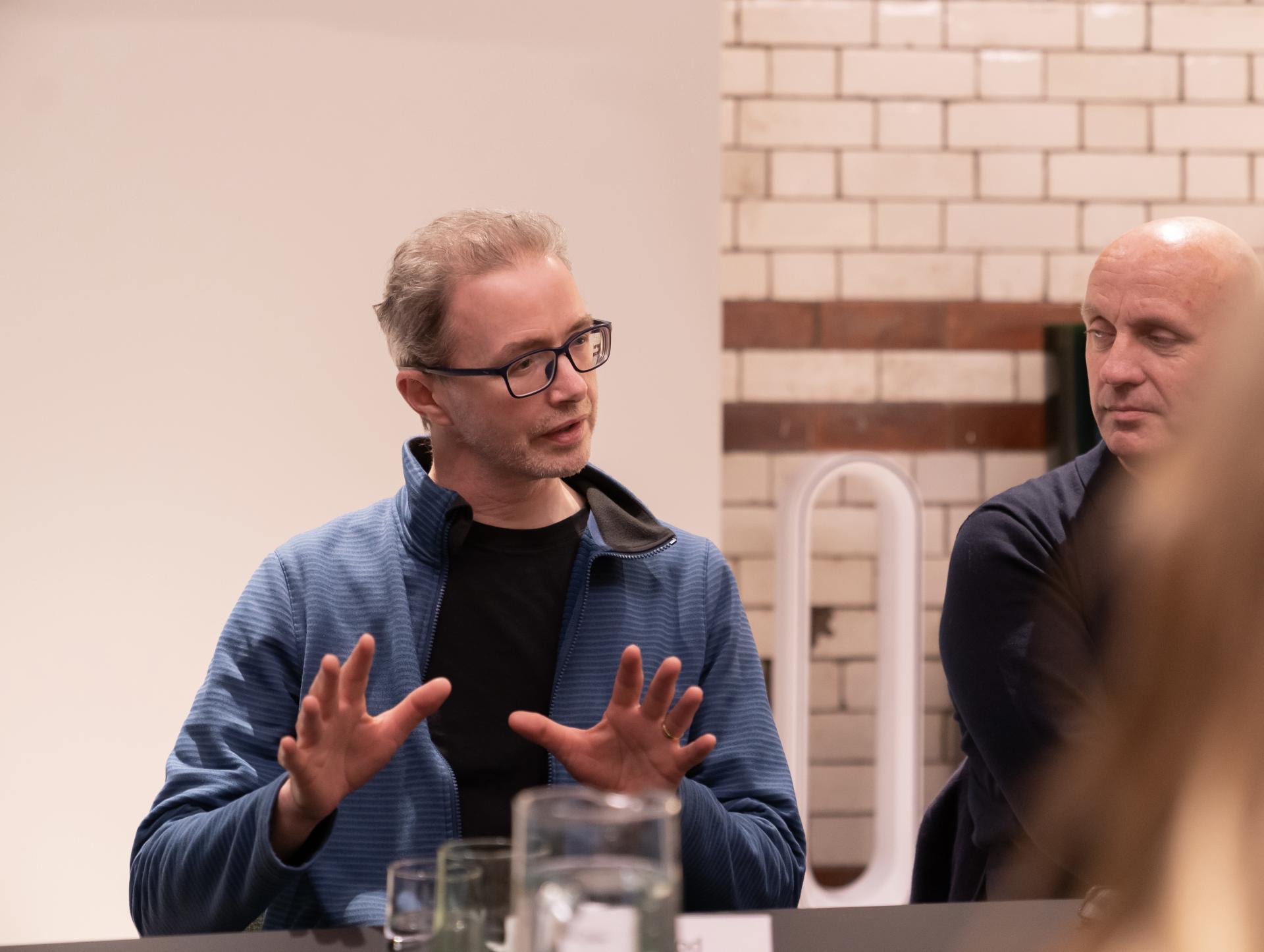 Professional discussing the impact of advanced technology in the workplace at a seminar, with engaged audience members.