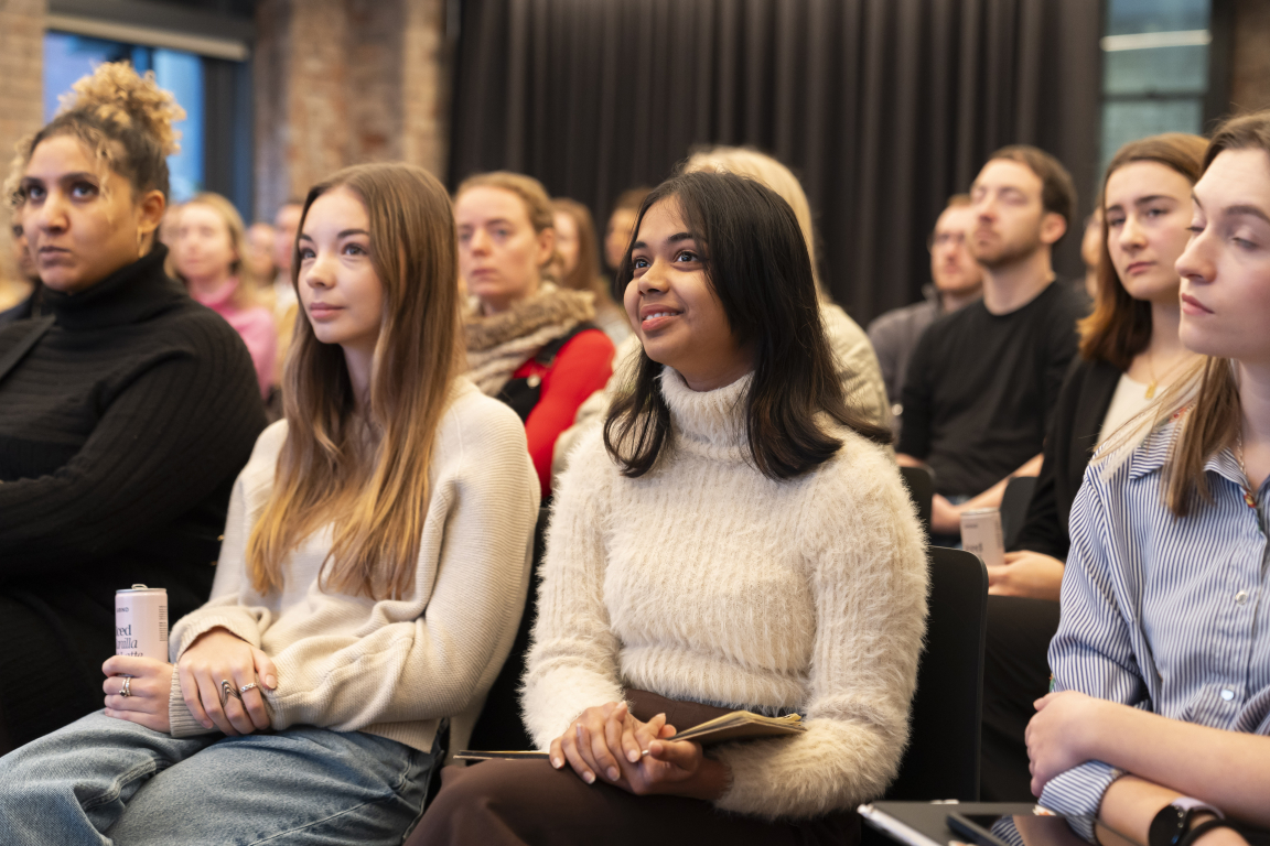 Audience members attentively listening during a celebration event at Material Source Studio Manchester, showcasing creative community engagement.