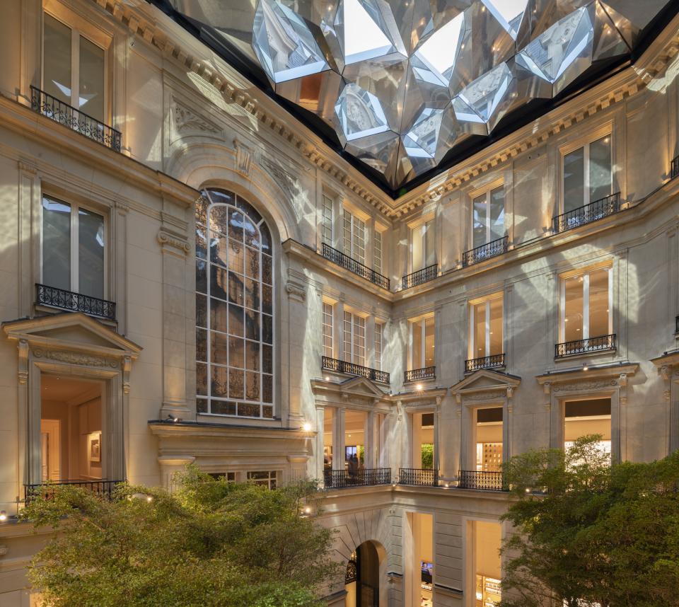 Foster + Partners' Apple Store features elegant Parisian architecture with a geometric glass ceiling and lush greenery in the courtyard.