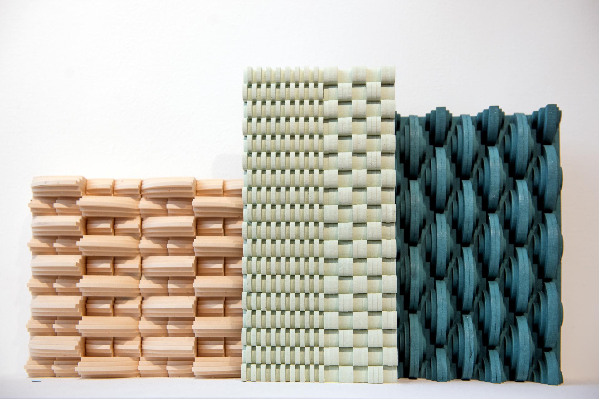 Innovative surface designs showcasing textured wood panels in beige, green, and teal displayed at the Surface Design Show 2020.