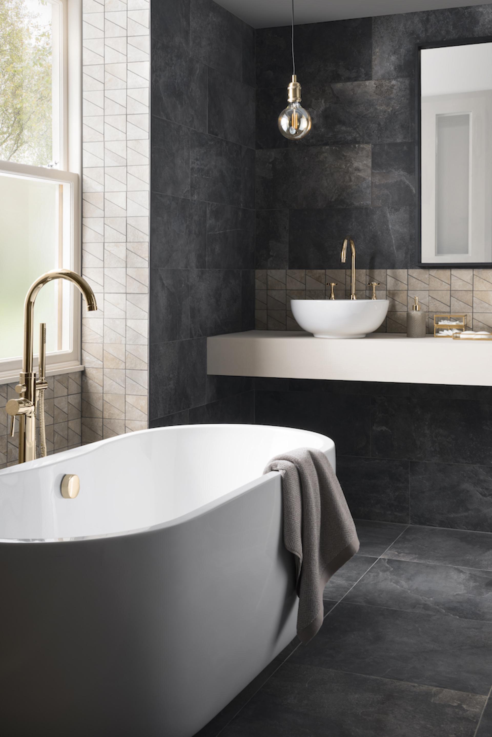 Luxurious modern bathroom featuring a freestanding tub, stylish tiles, and elegant gold fixtures for housebuilder inspiration.