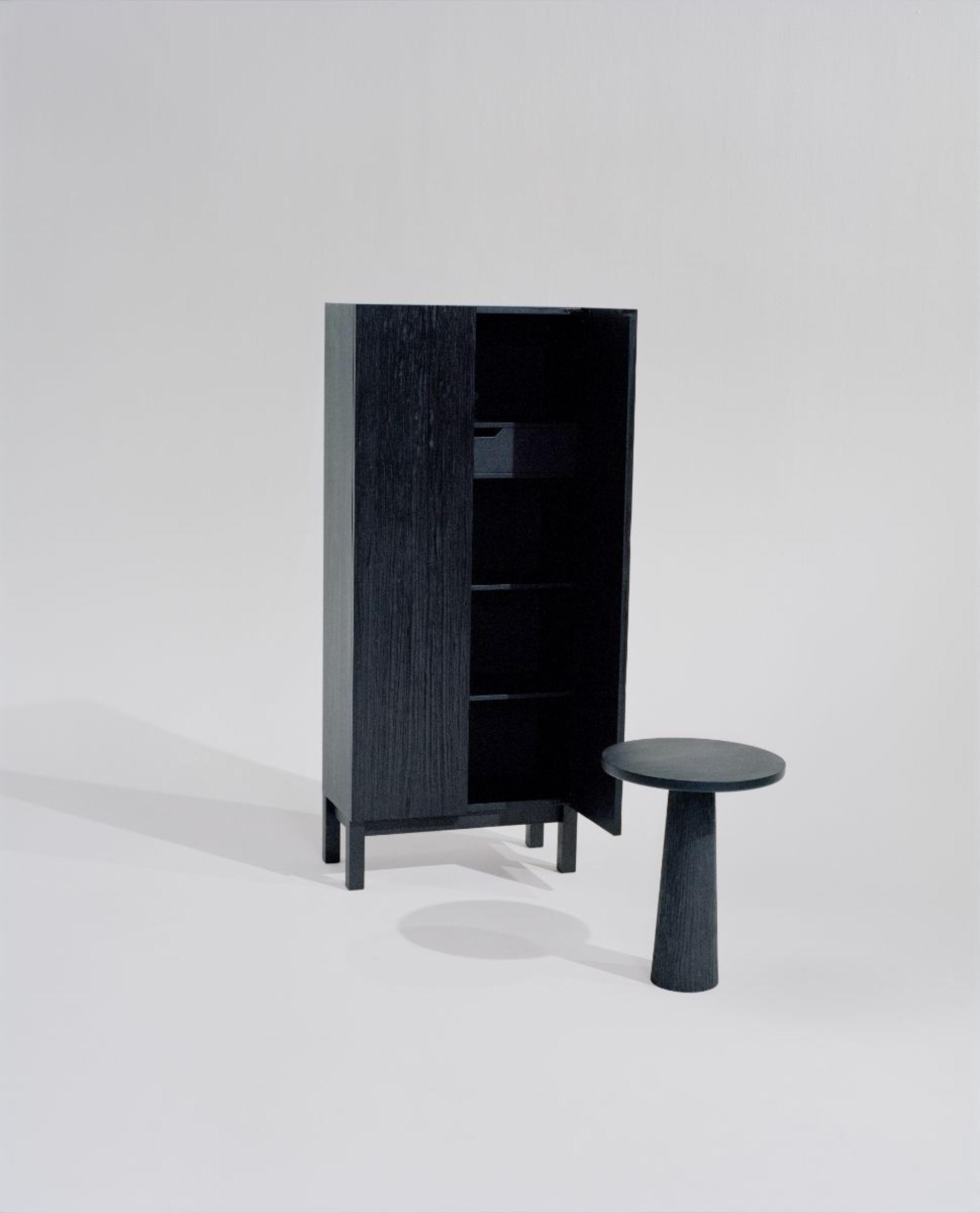 Contemporary furniture pieces showcasing Norway’s circular-design economy, featuring a black cabinet and round side table.