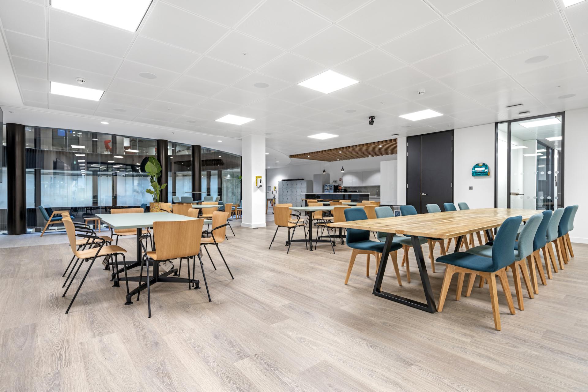 Modern office workspace featuring stylish tables and chairs, emphasizing collaborative design and functionality for a dynamic workplace.