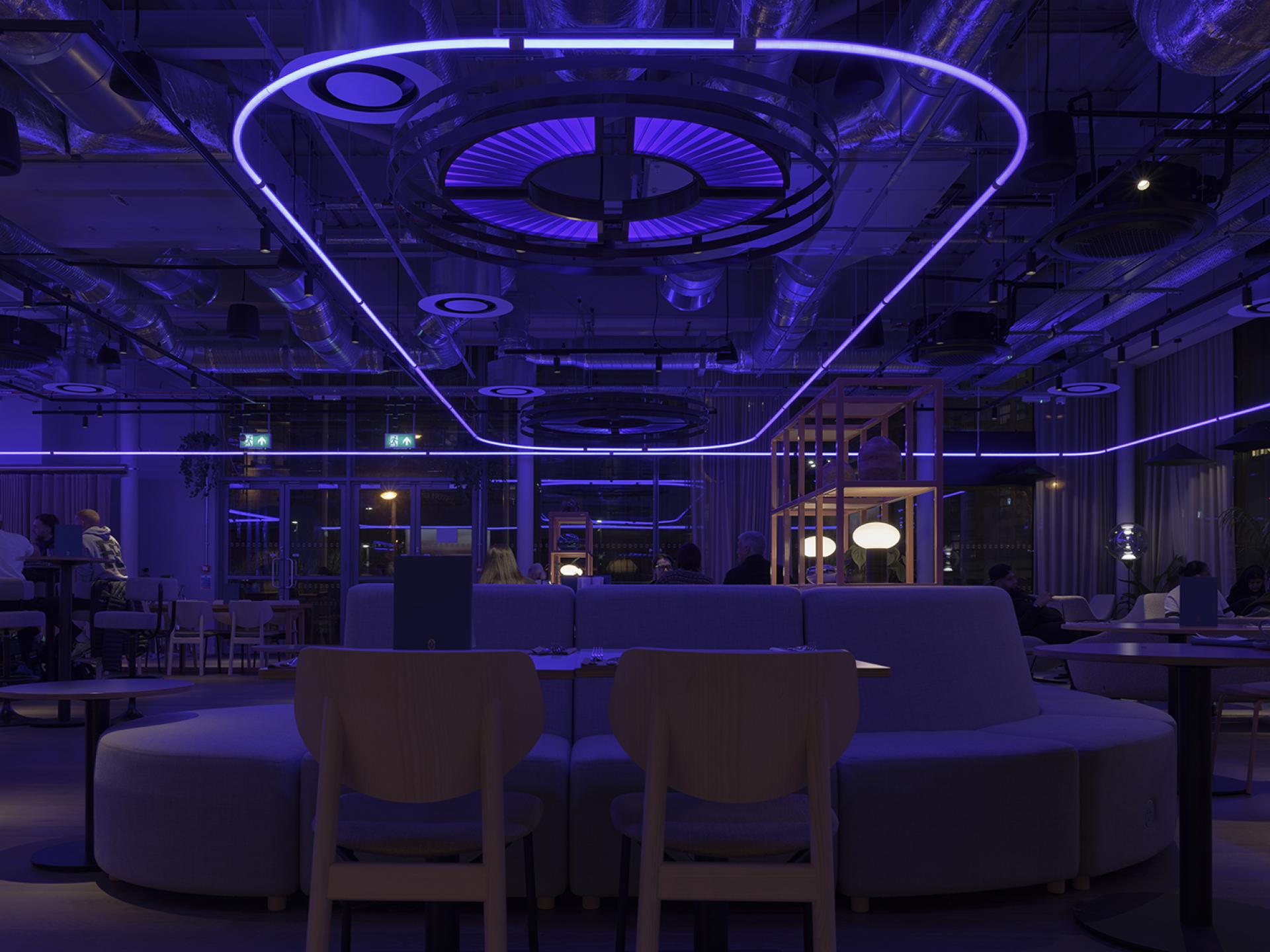 Modern interior of Junction at Manchester Central featuring ambient purple lighting, contemporary seating, and a collaborative atmosphere.