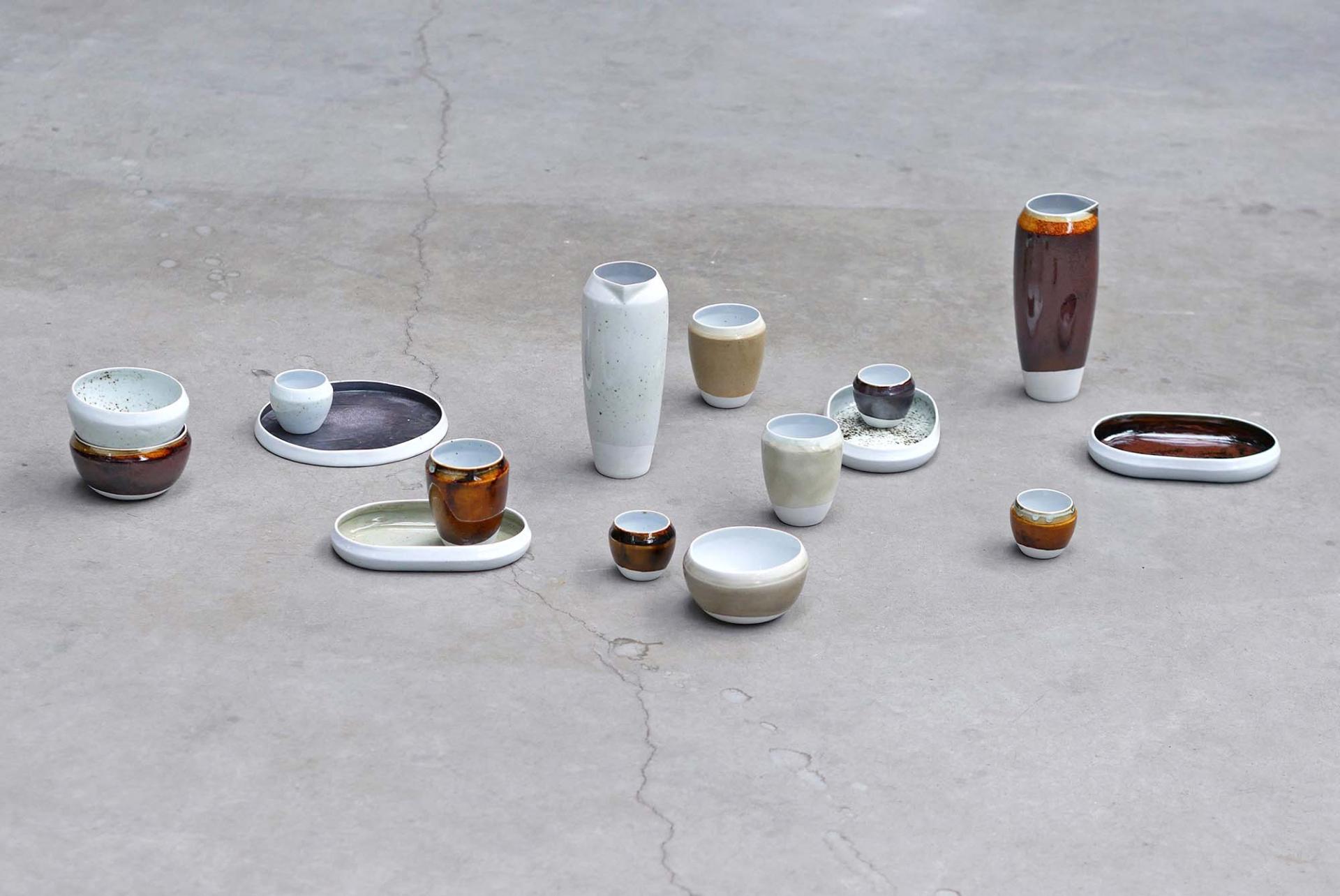 Ceramic vessels and bowls in various colors and shapes, showcasing Agnė Kučerenkaitė's innovative design and waste re-identification.