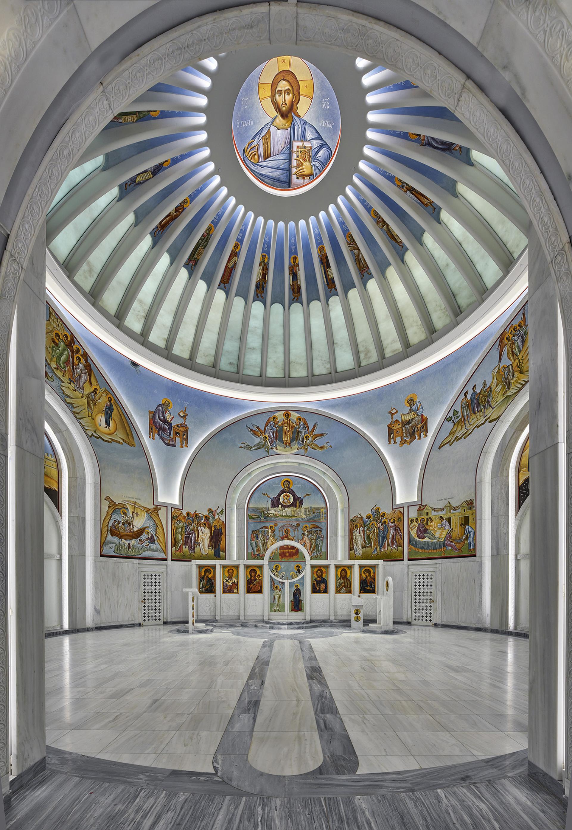 Interior view of a beautifully designed church featuring ornate frescoes and a domed ceiling, showcasing Calatrava's architectural artistry.
