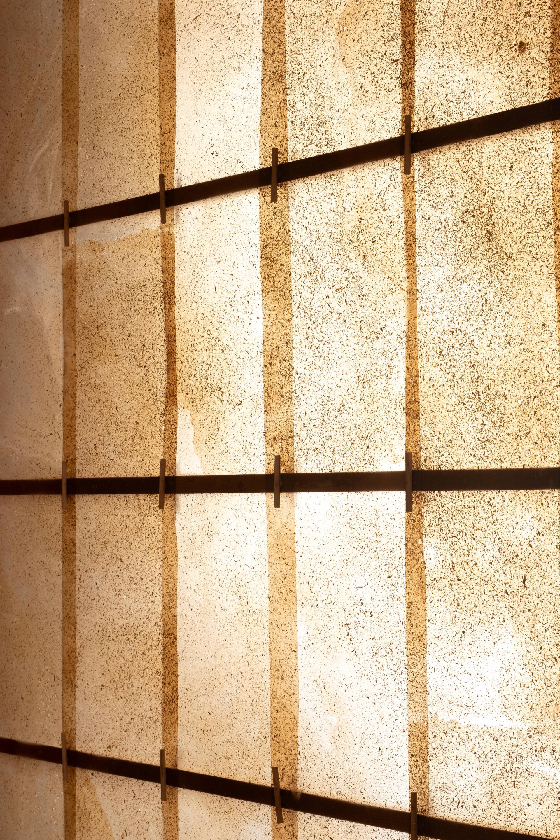Translucent wood panels with textured surfaces are backlit, showcasing the architectural potential of natural materials in design.