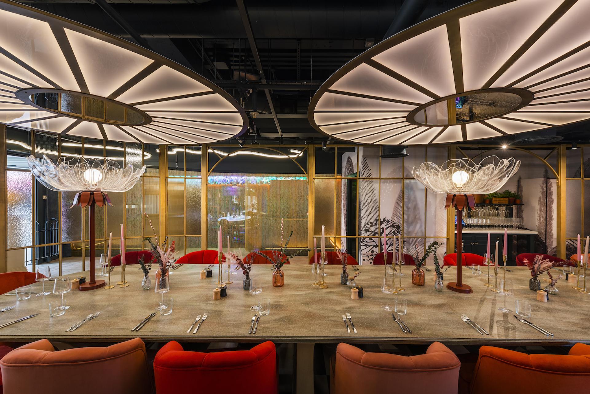 Elegant dining setup with artistic lighting and colorful seating, embodying a whimsical Wonderland theme.