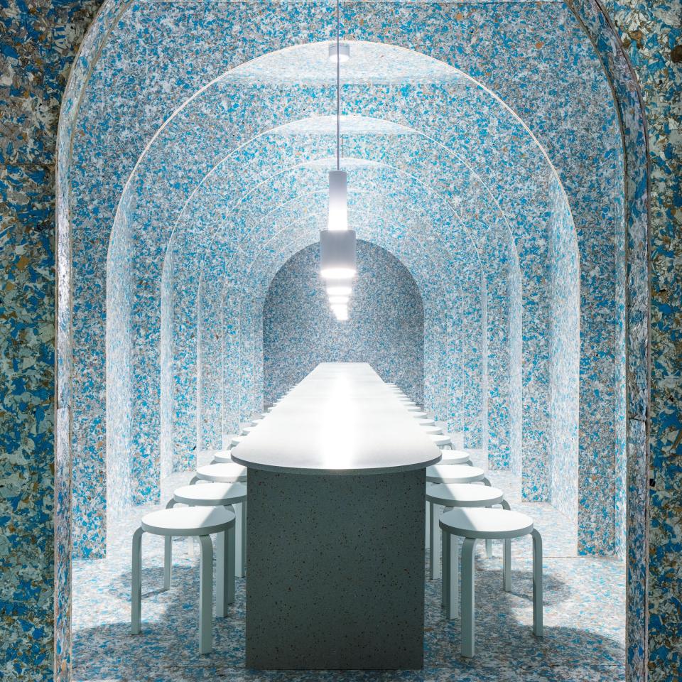 Brightly colored bistro interior featuring a long table and stools, designed with sustainable materials for a zero waste concept.