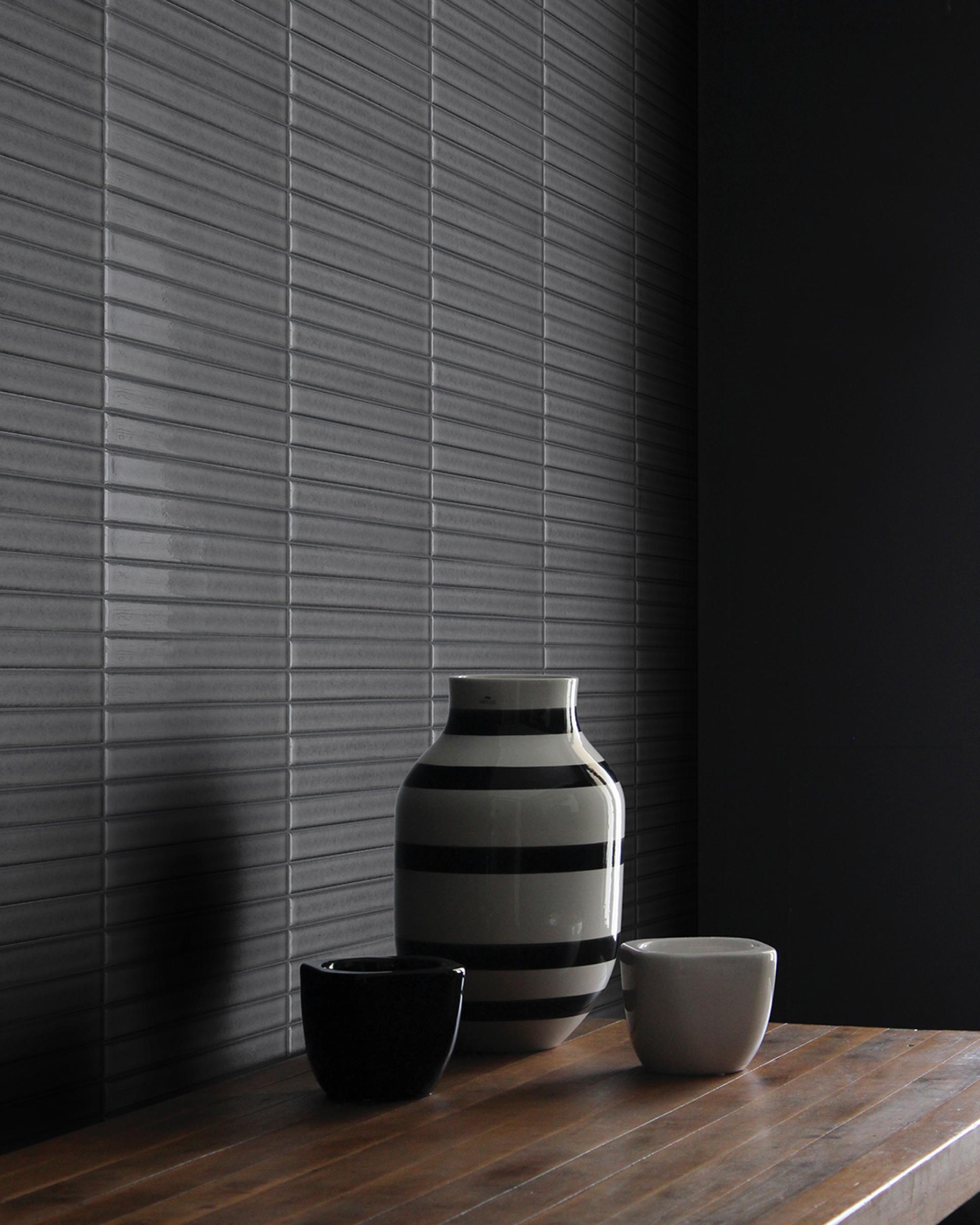 Porcelain mosaic tiles inspired by Japanese glazing, displayed with decorative vases on a wooden surface.