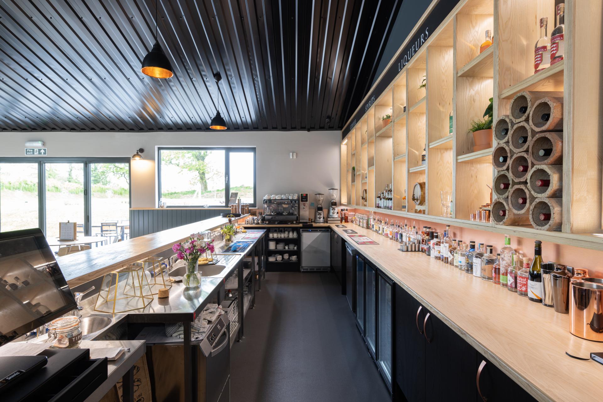 Stylish bar interior featuring a range of spirits and liqueurs, reflecting The English Spirit Distillery's modern design.