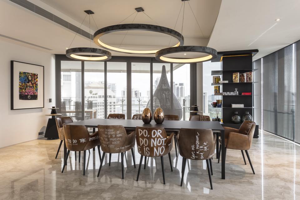 Stylish dining area with artistic chairs and modern decor, showcasing Elliot James' award-winning interior design in Singapore.
