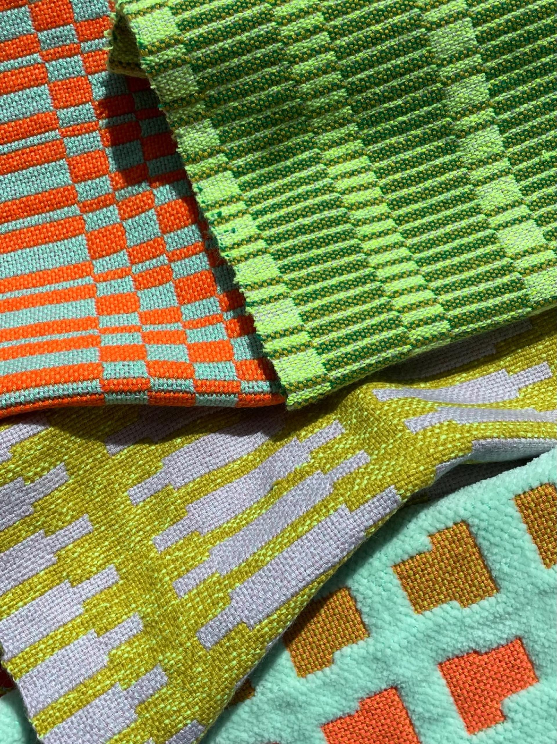 Colorful woven fabric samples featuring intricate patterns and textures, displayed at the New Designers 2022 event.