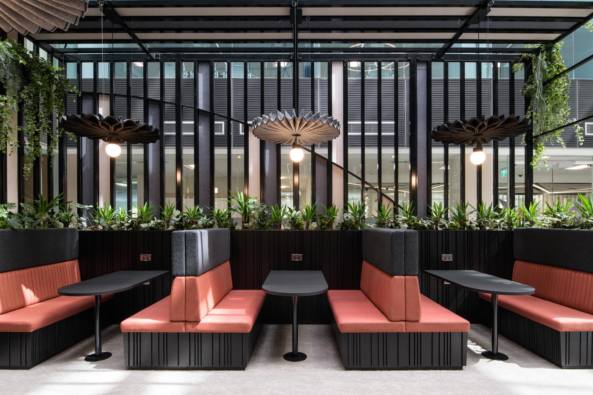 Modern seating area with greenery, designed by SpaceInvader, enhances the interior at Manchester's One Piccadilly Gardens.