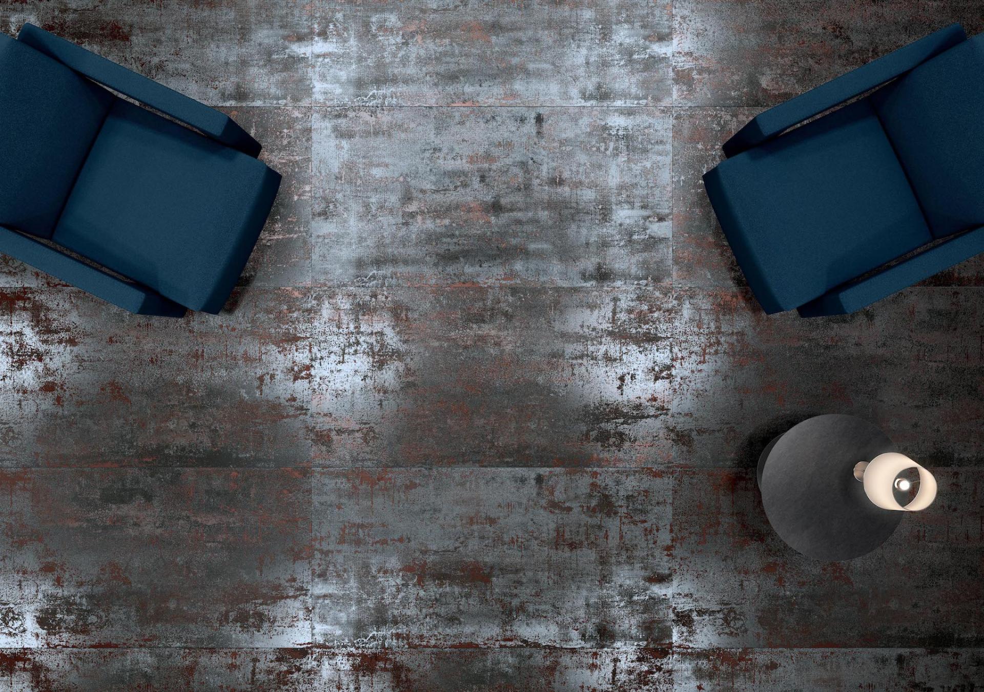 Stylish blue chairs on a textured gray tile floor, showcasing modern Spanish tile design trends.