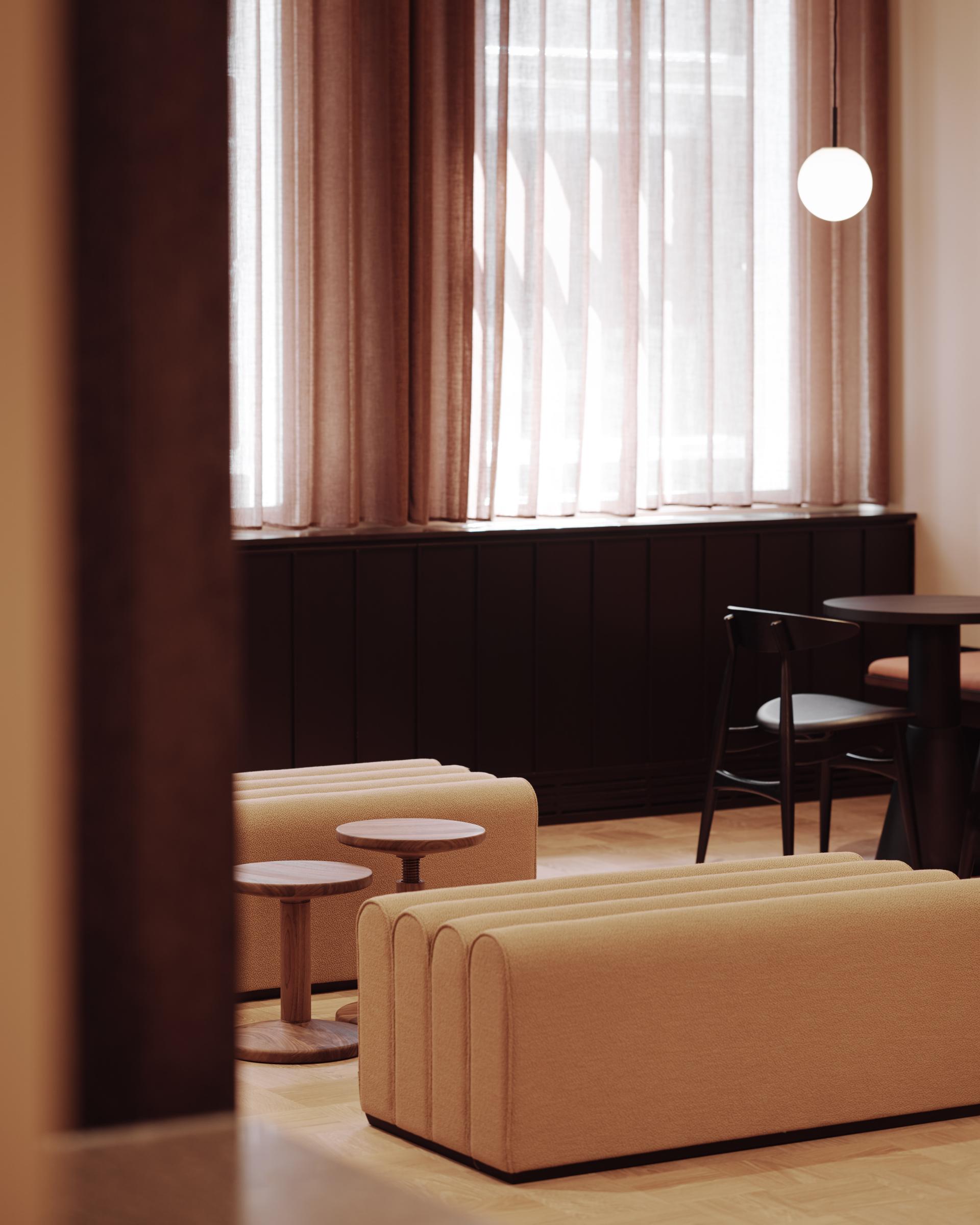 A cozy seating area in Summit House features stylish beige sofas and wooden tables, creating an inviting workspace atmosphere.