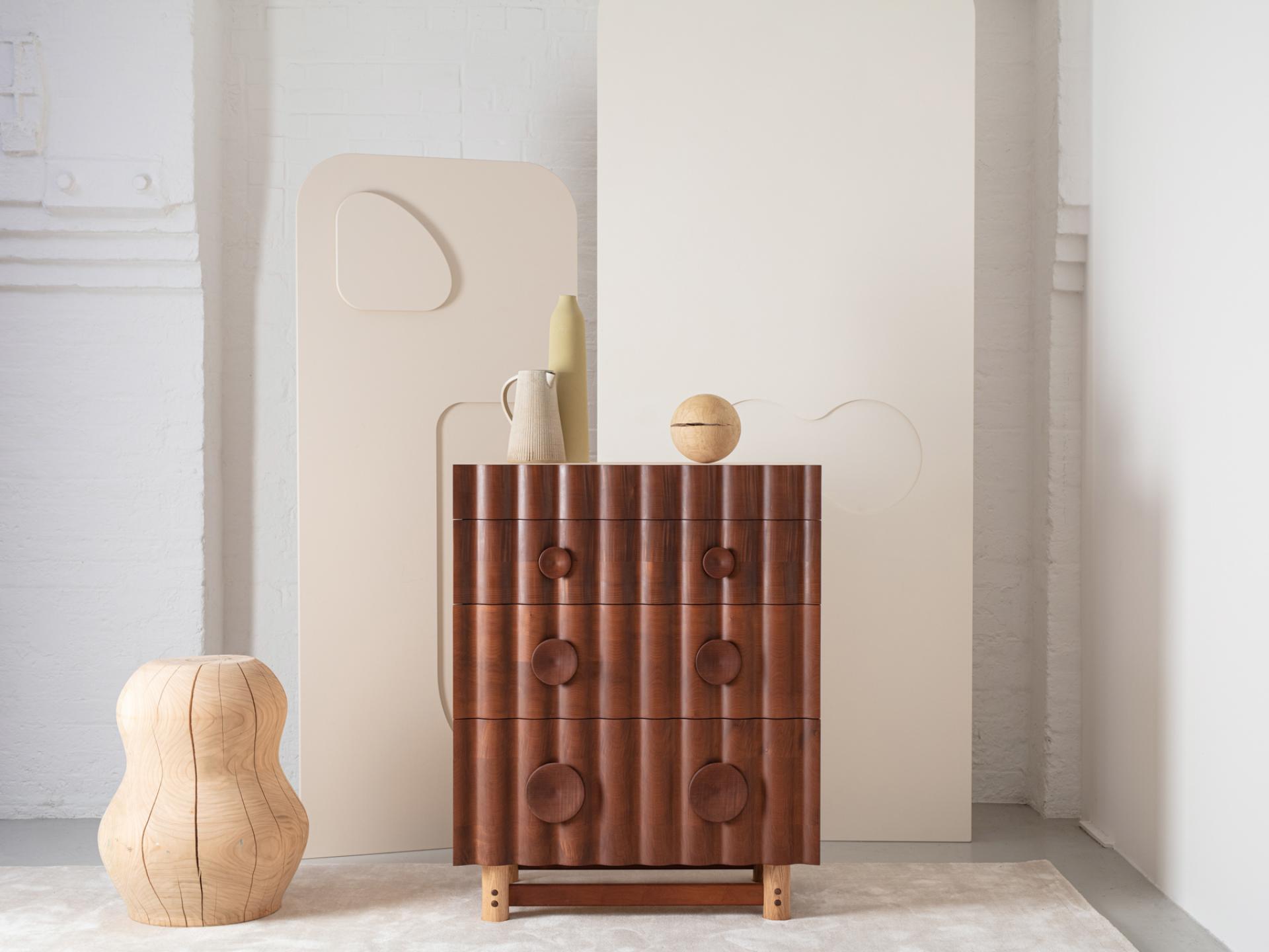 Stylish wooden dresser with rounded knobs, accompanied by organic-shaped decor elements, featured in the Wood Awards 2021 shortlist.