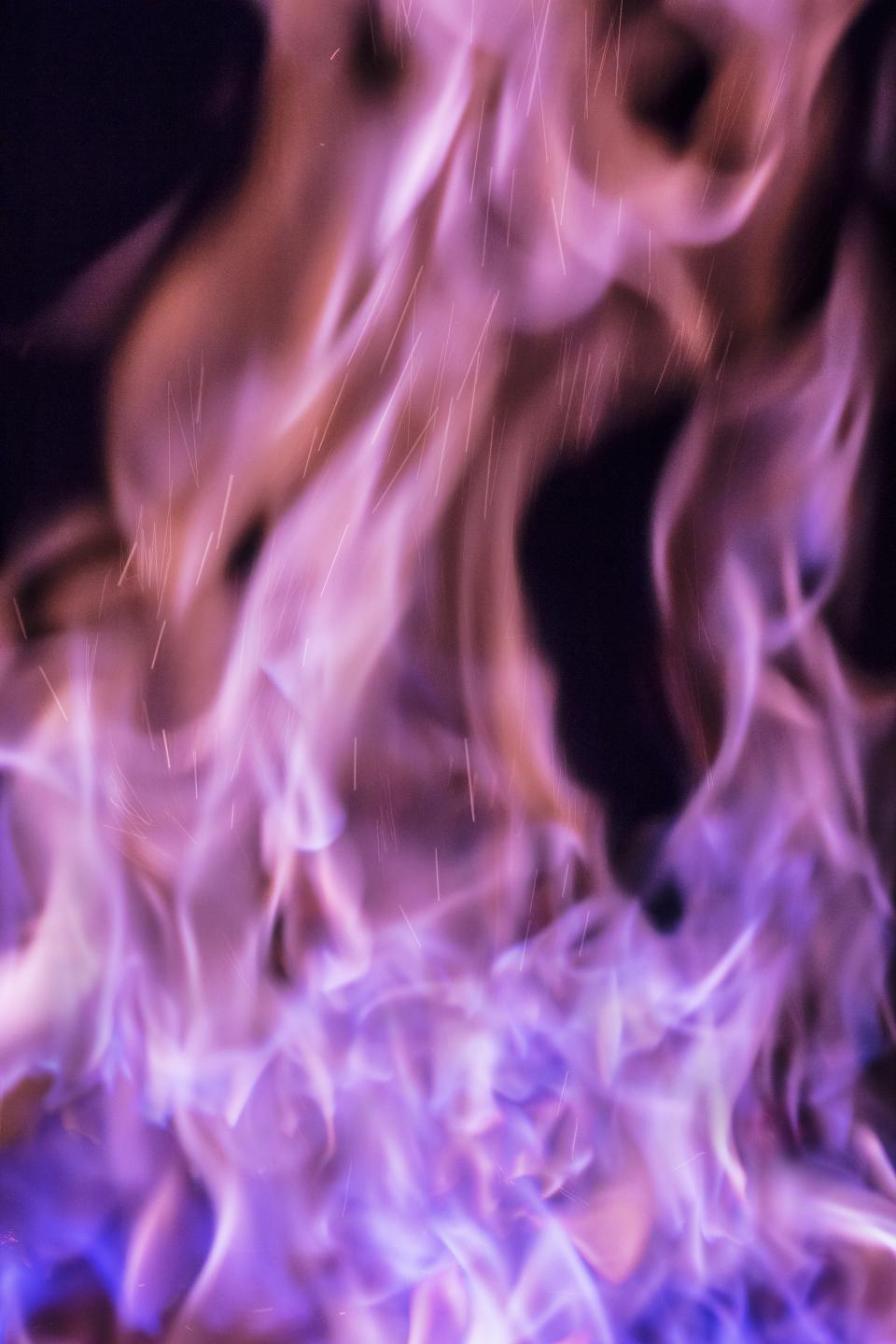 Dynamic flames with purple hues, illustrating the craftsmanship of metalwork at the Biology of Metal exhibit in Tsubame-Sanjo.