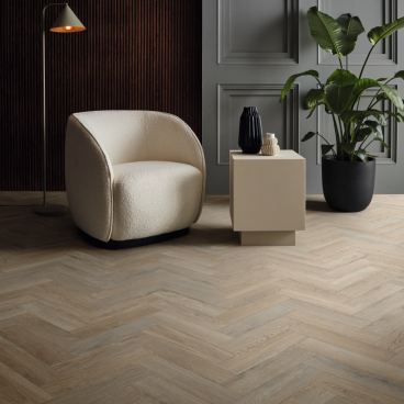 Stylish interior featuring classic oak herringbone flooring, modern furniture, and decorative plants, embodying quiet luxury.