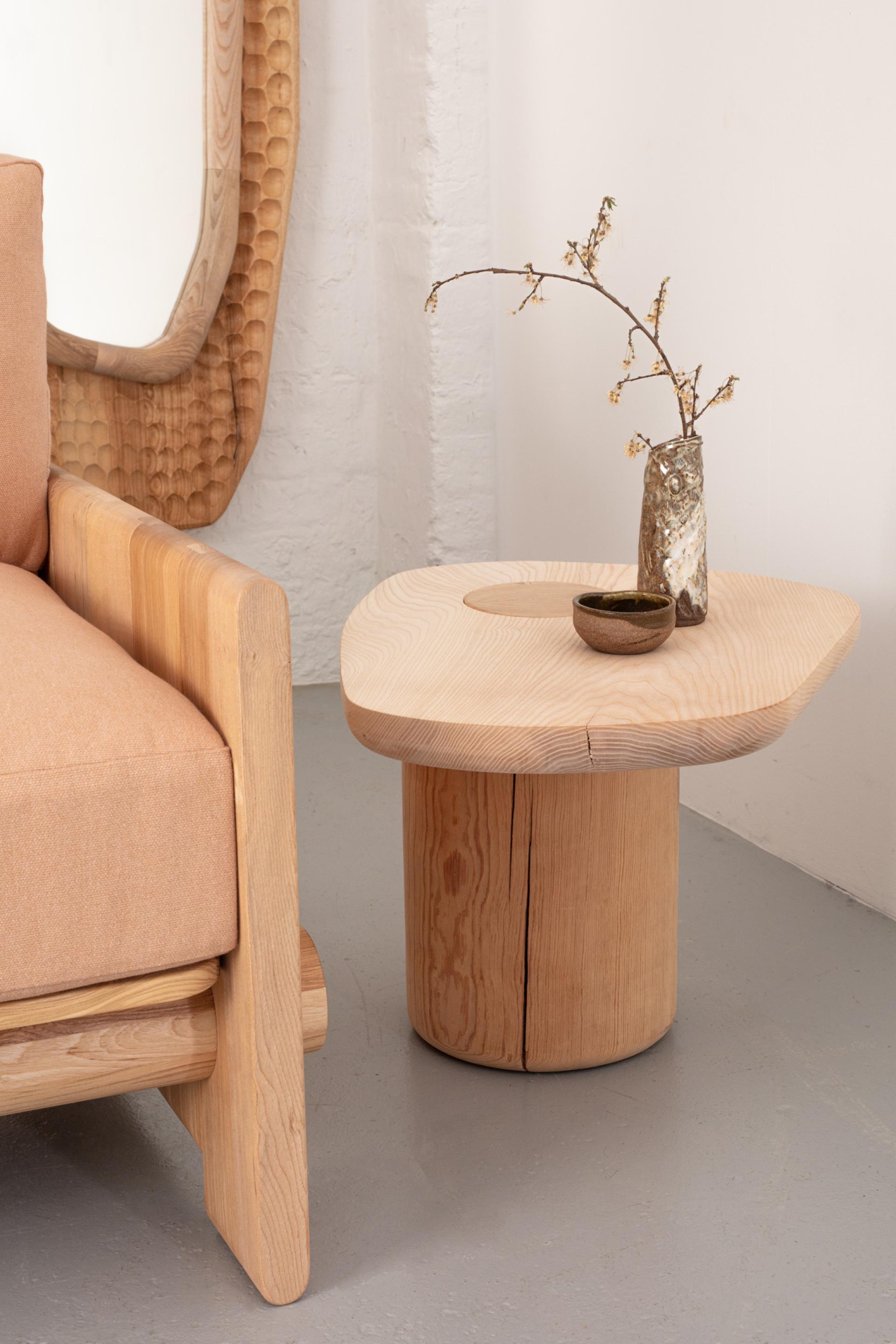 Stylish wooden coffee table featuring organic shapes, paired with cozy, modern upholstery in a minimalist interior setting.