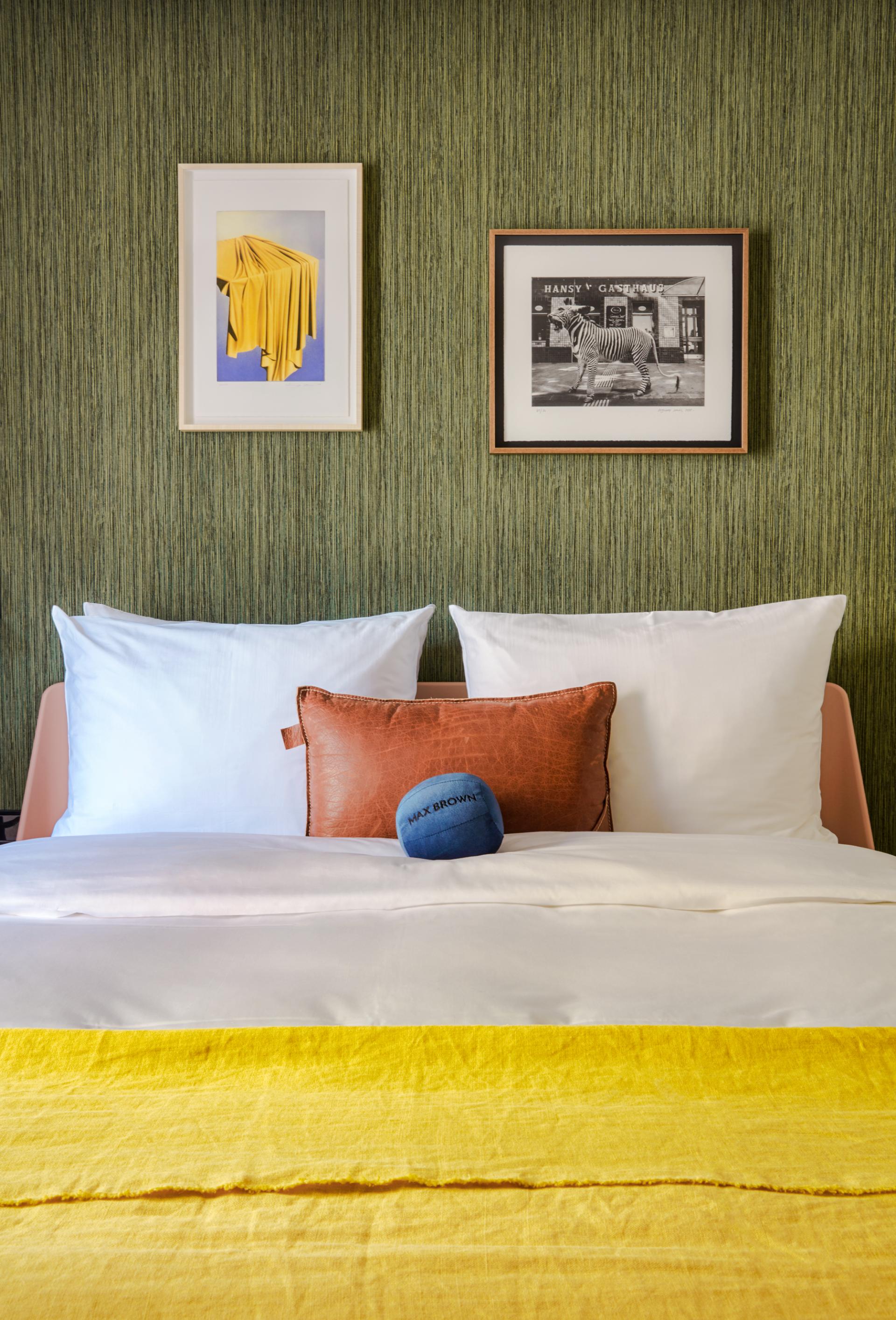 Cozy hotel room at Max Brown 7th District, featuring playful art and vibrant decor in Vienna's Neubau neighborhood.