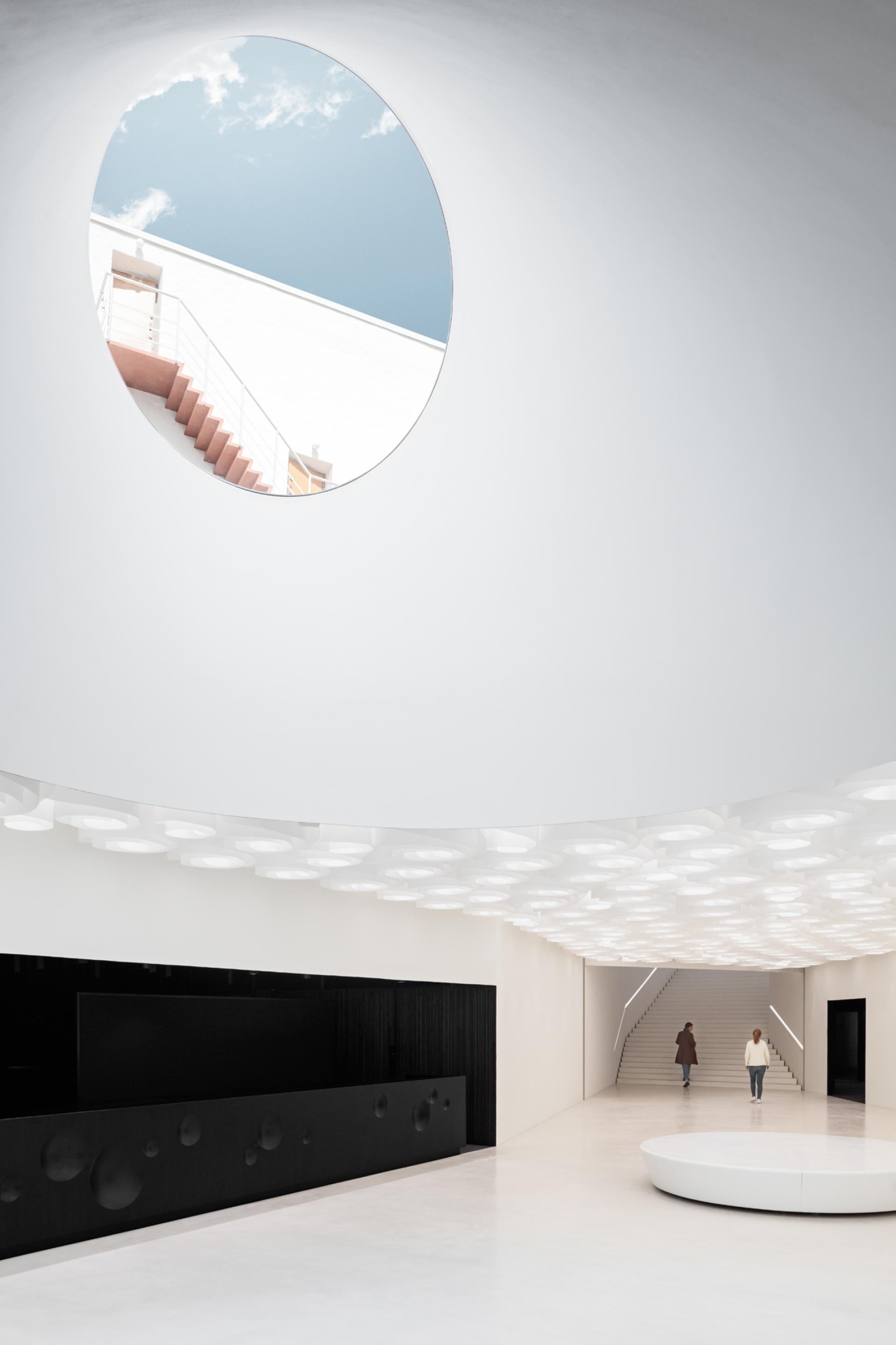 Modern interior of Helsinki's new art museum, featuring a circular skylight and minimalist design elements.