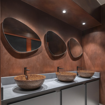 Elegant washroom featuring three unique bowls, stylish mirrors, and a warm copper backdrop at Material Source Studio Glasgow.