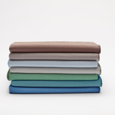 Fabric samples in various colors showcasing Camira's sustainable textile innovation using recycled marine plastic.