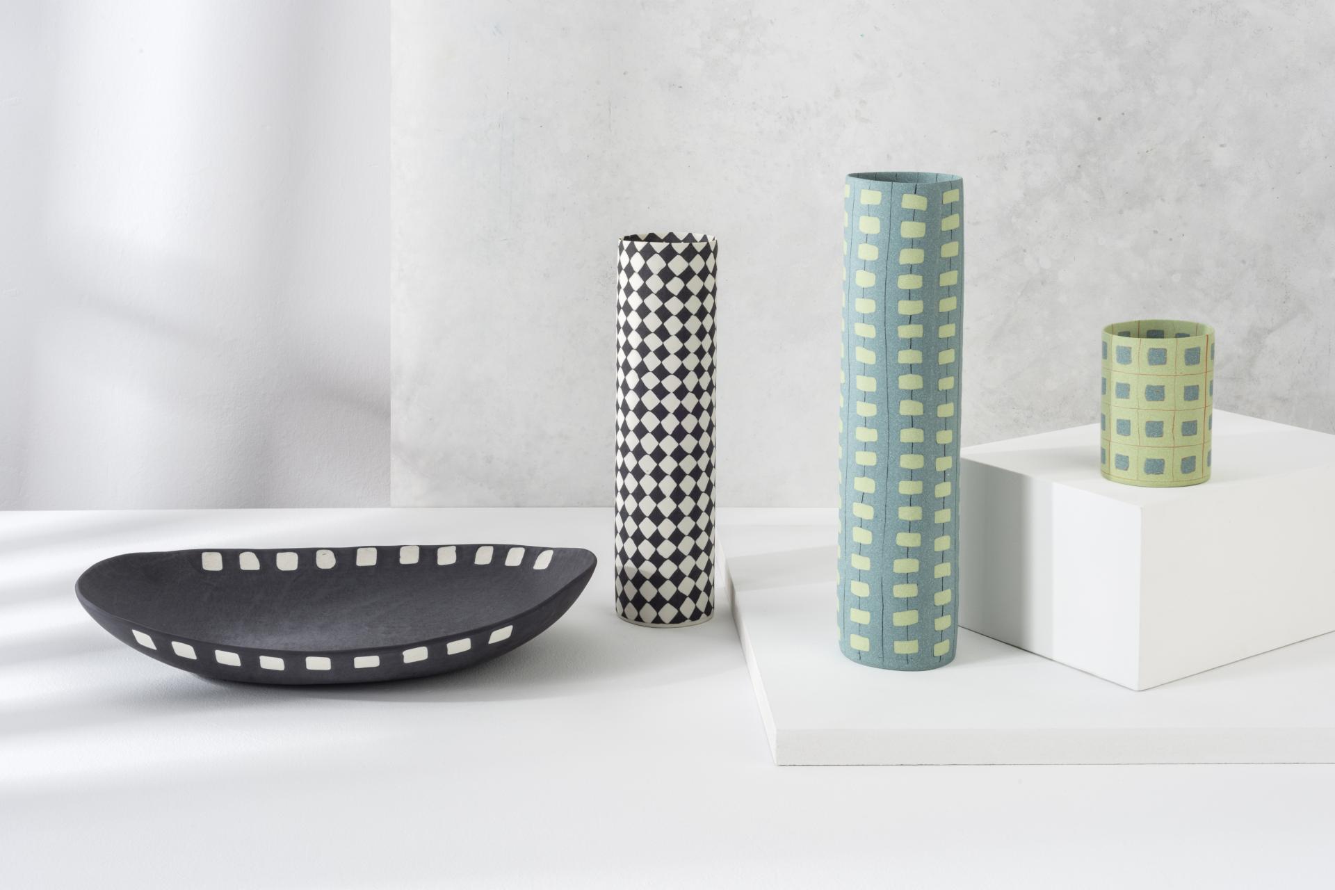 Stylish ceramic vases and a bowl displayed on a white surface, showcasing contemporary design at London Craft Week 2024.