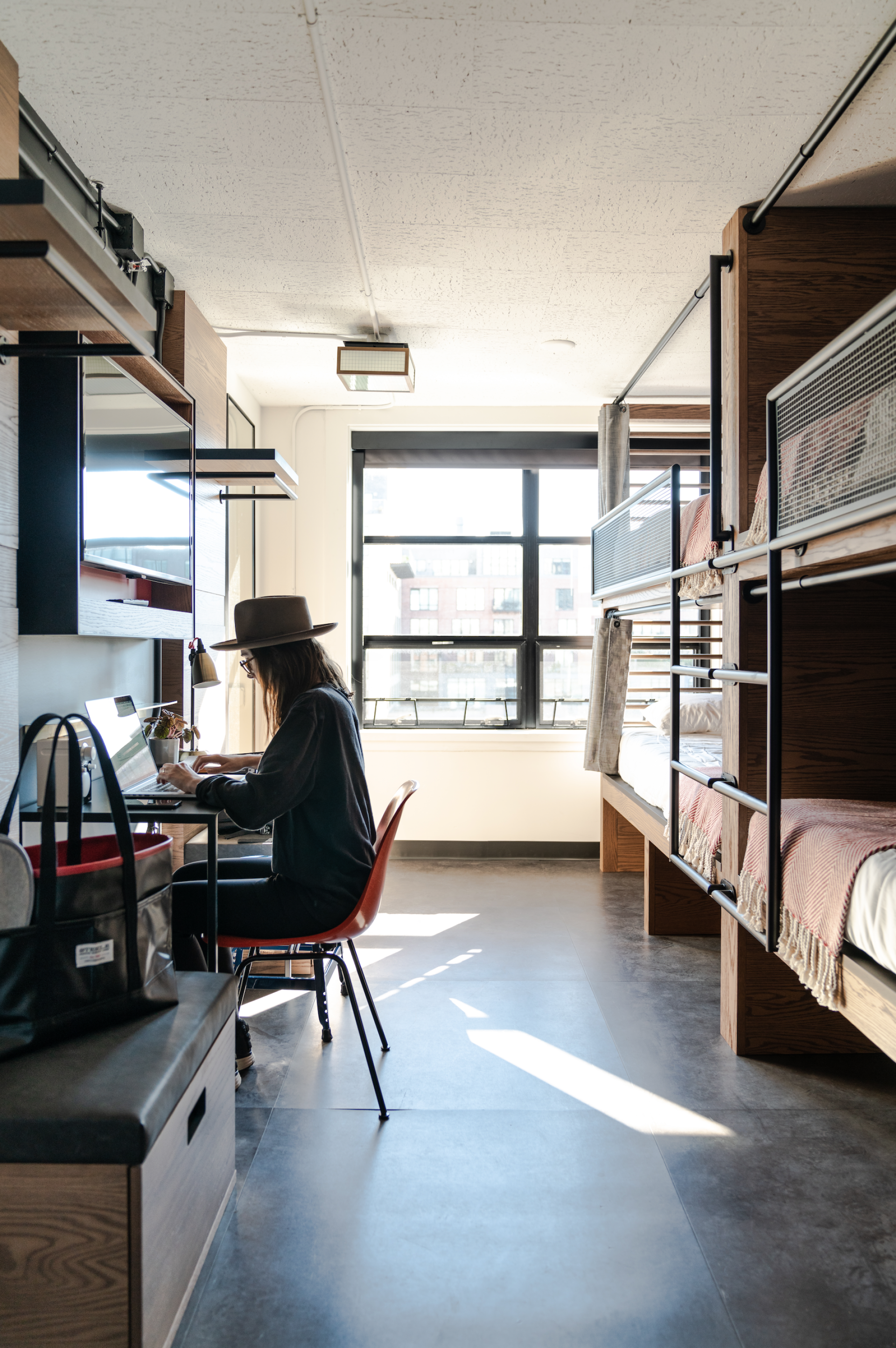 Stylish interior of The Revolution Hotel showing a workspace and bunk beds, reflecting Boston's heritage in design.