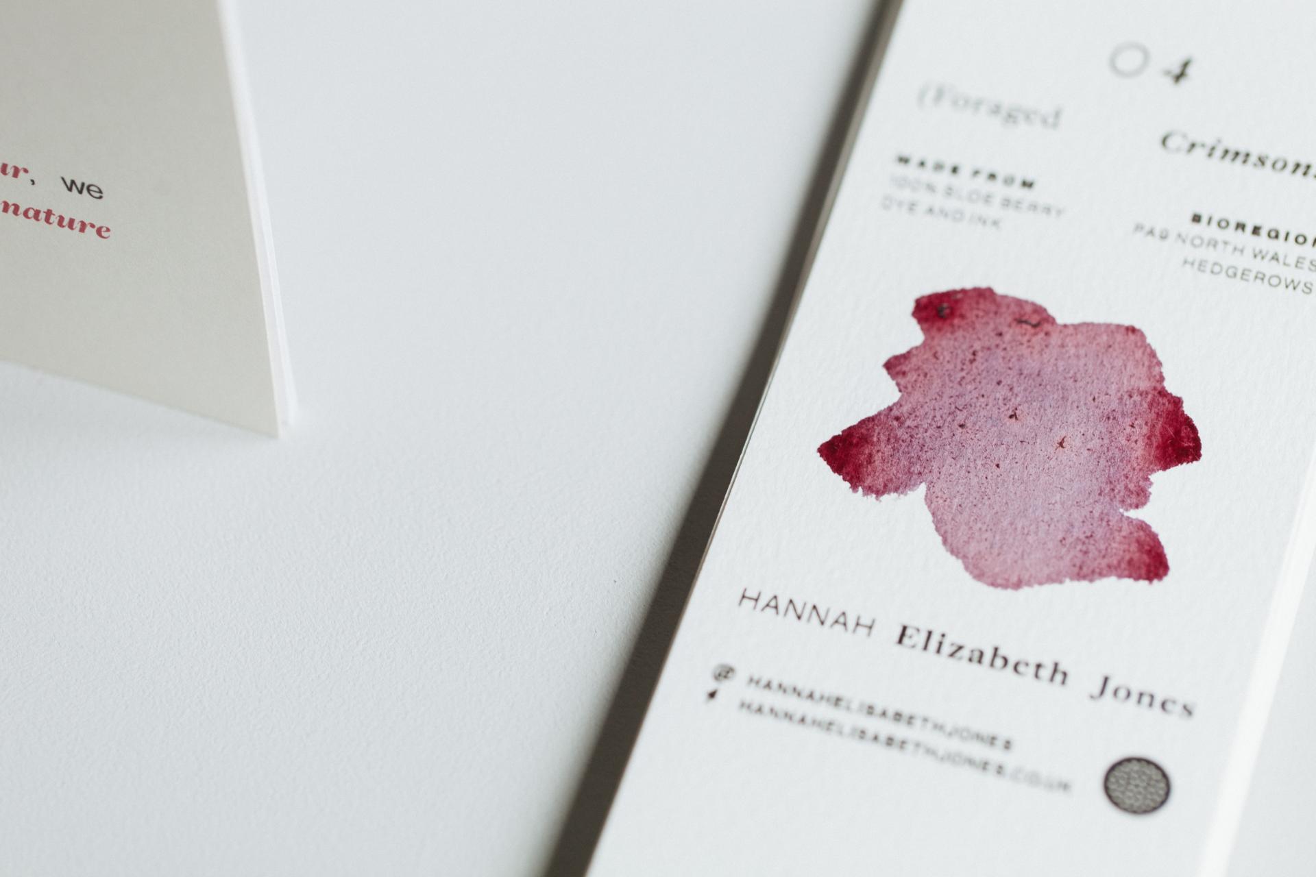 Swatch card displaying a crimson dye made from foraged berries, showcasing sustainable color practices in design.