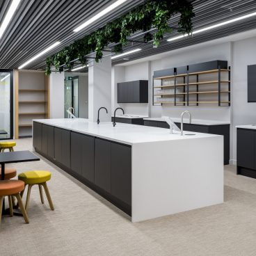 Modern office kitchen featuring sleek cabinetry and an island design, supporting the first WELL certified office in Scotland.