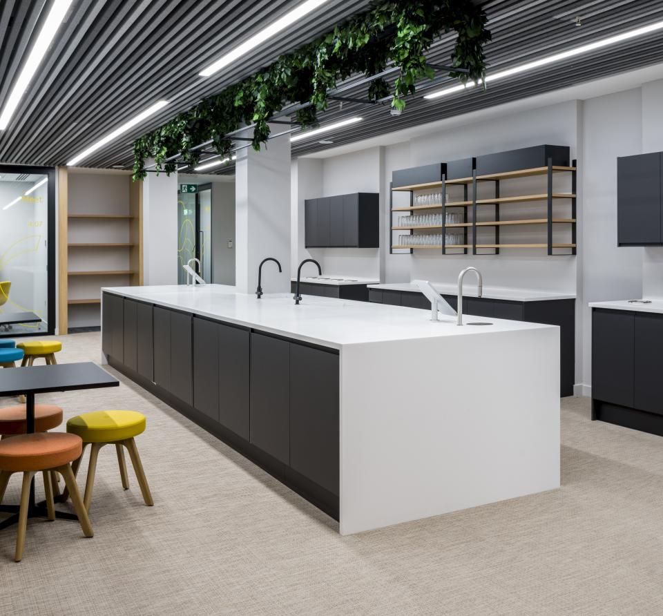 Modern office kitchen featuring sleek cabinetry and an island design, supporting the first WELL certified office in Scotland.