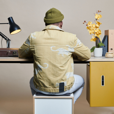 Modern workspace featuring Bisley's Buddy personal storage solution, desk lamp, and decorative flowers in a stylish setting.