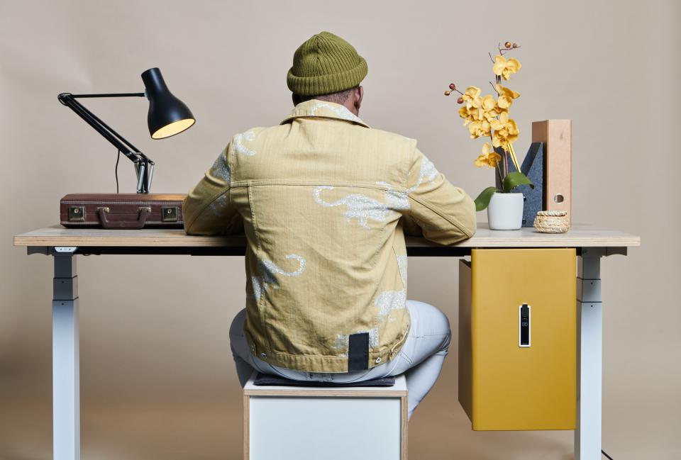 Modern workspace featuring Bisley's Buddy personal storage solution, desk lamp, and decorative flowers in a stylish setting.