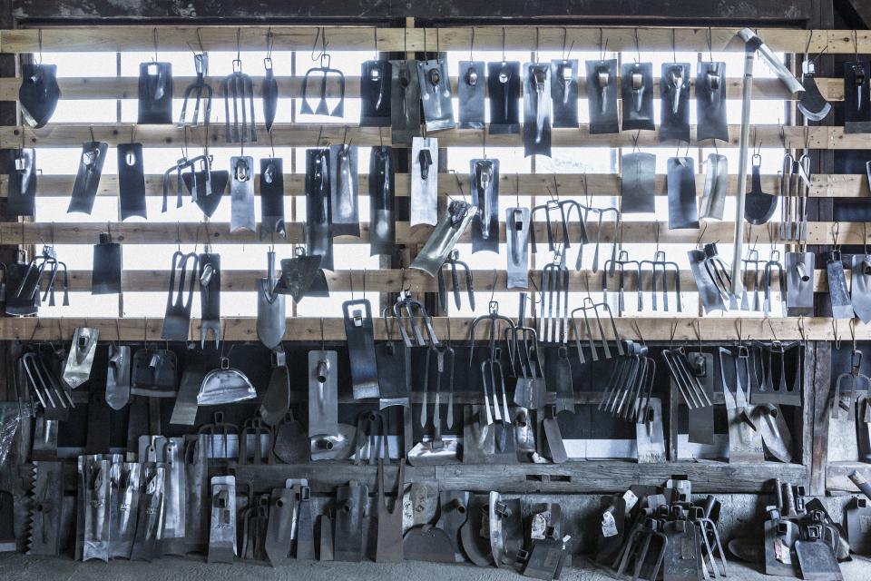 Collection of traditional metal tools displayed on a wooden wall, showcasing craftsmanship from Tsubame-Sanjo at Japan House London.