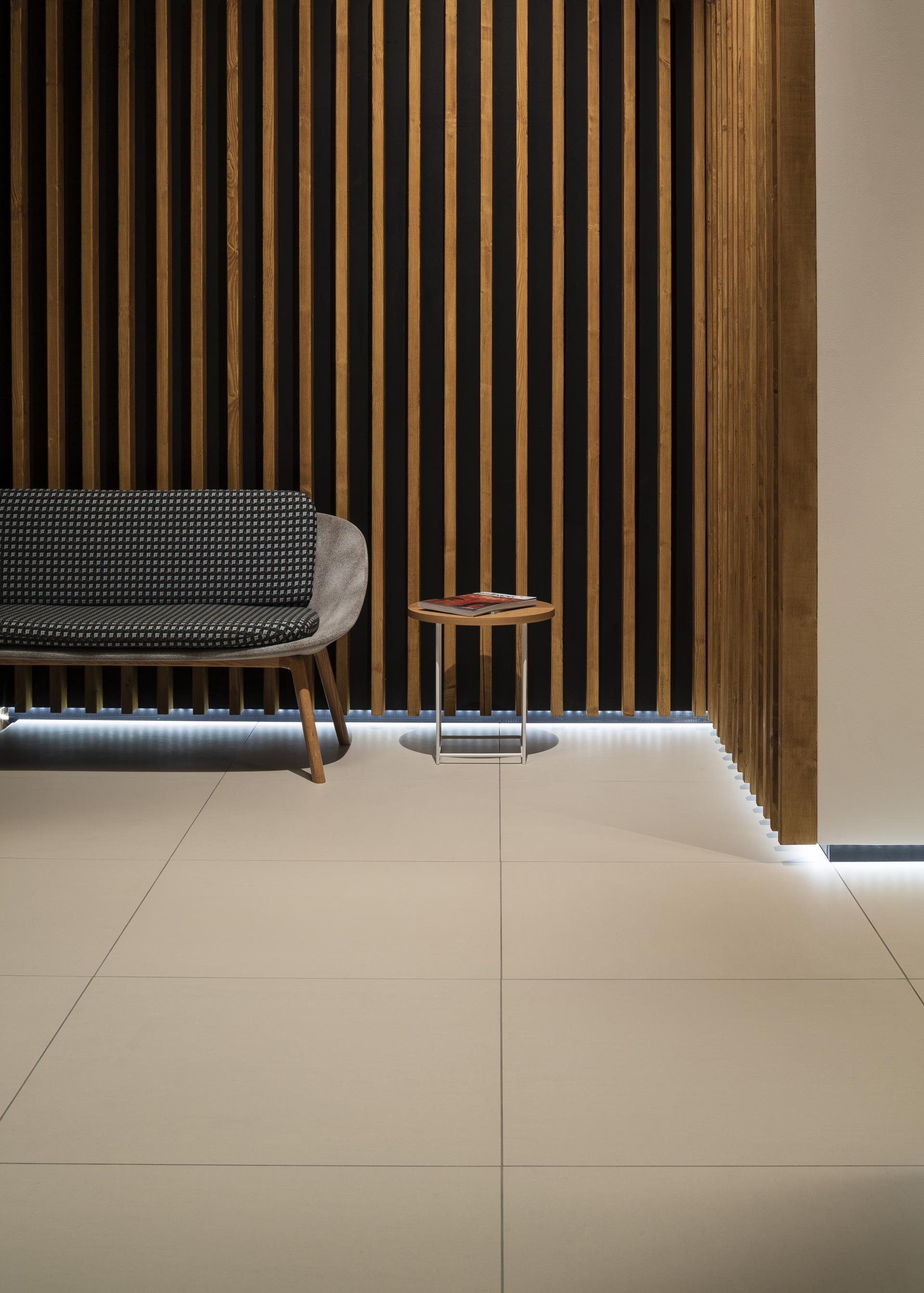 Modern seating area featuring a stylish sofa and wooden accent wall, showcasing PARKSIDE's tile design collaboration.