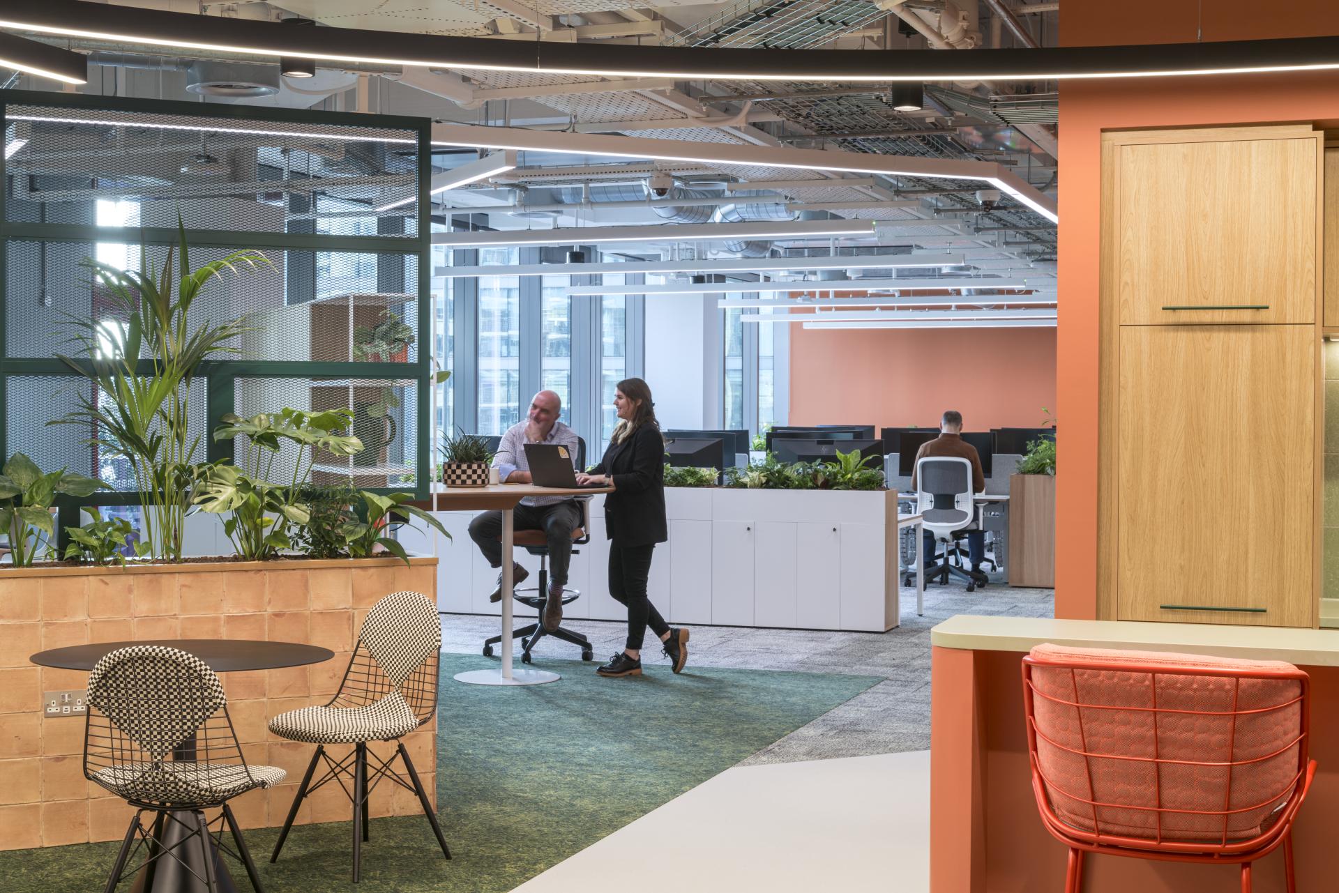 Modern office interior of Virgin Media O2's headquarters, featuring collaborative spaces, greenery, and contemporary design elements.