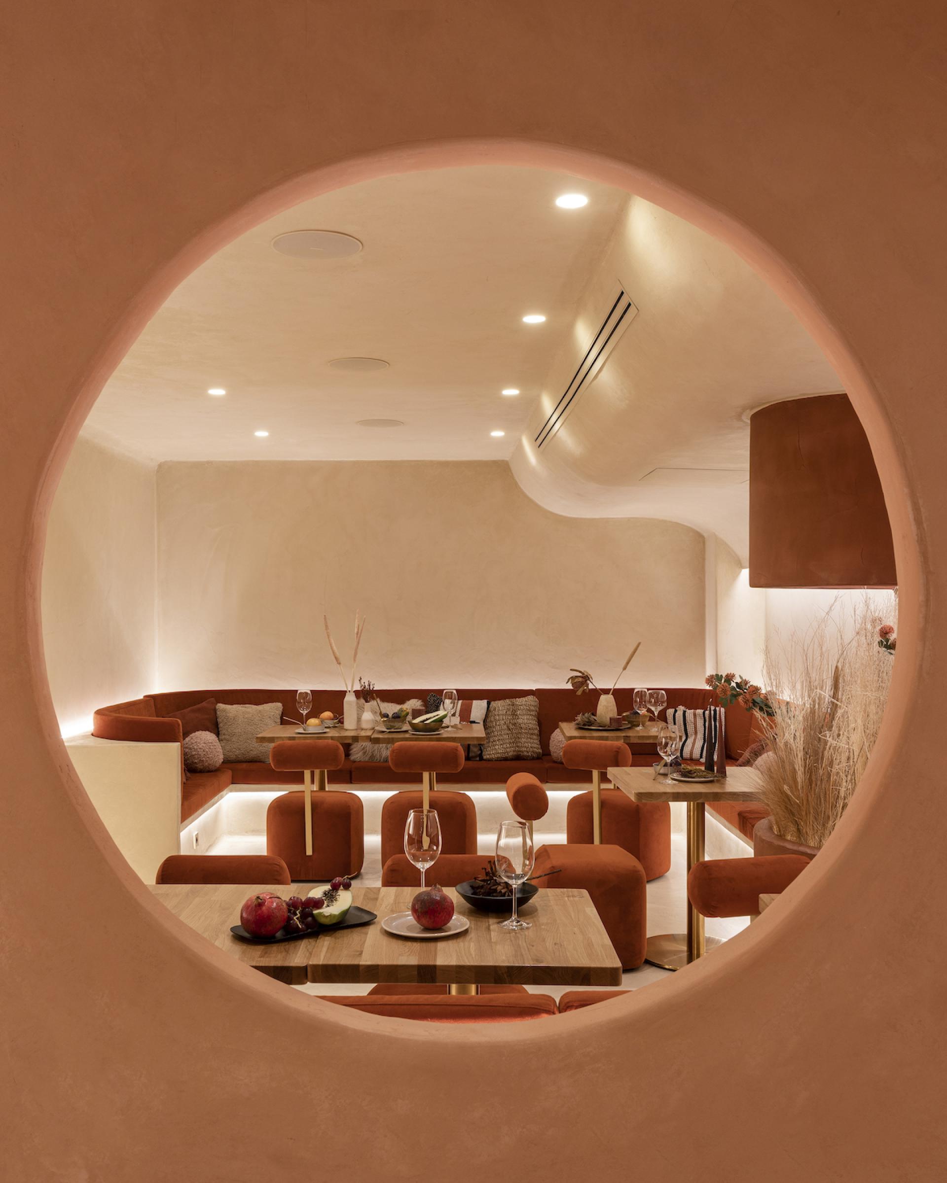 Elegant interior of Living Bakkali restaurant, showcasing Middle Eastern-inspired design with plush seating and decorative fruits.