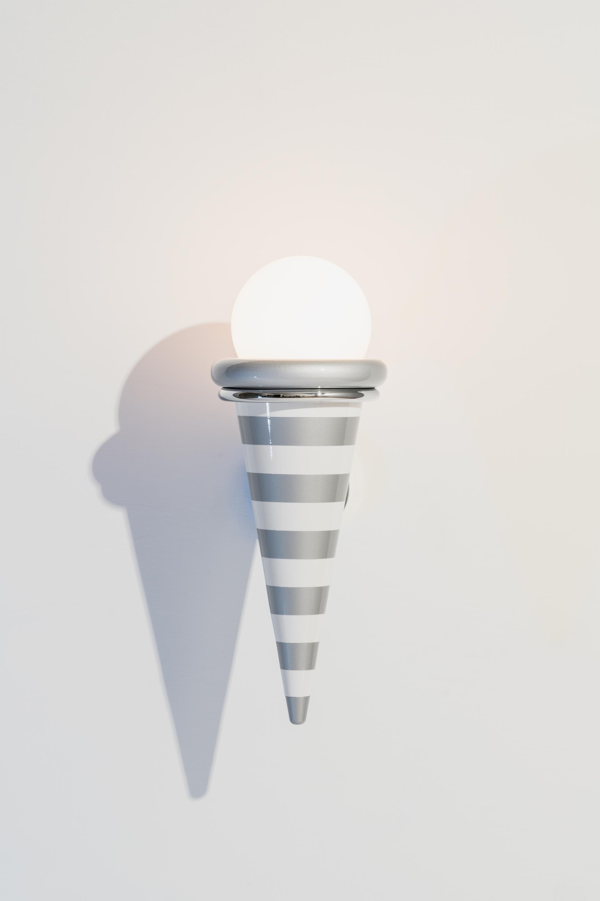 Stylish striped wall lamp featuring a round light, representing the playful design aesthetic of the Memphis movement.