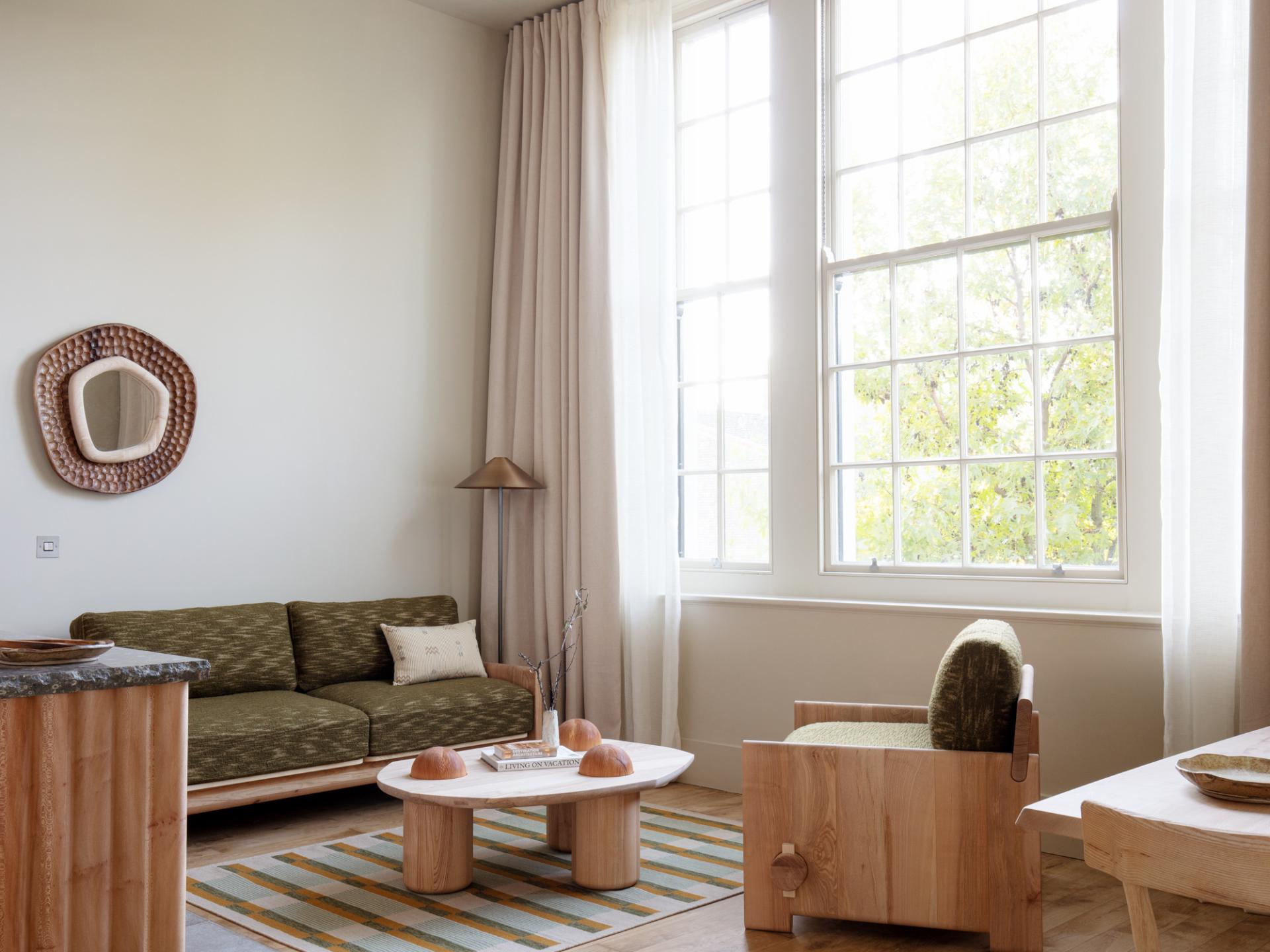 Cozy interior featuring Jan Hendzel's expressive furniture, including a green sofa, unique chair, and a stylish coffee table.