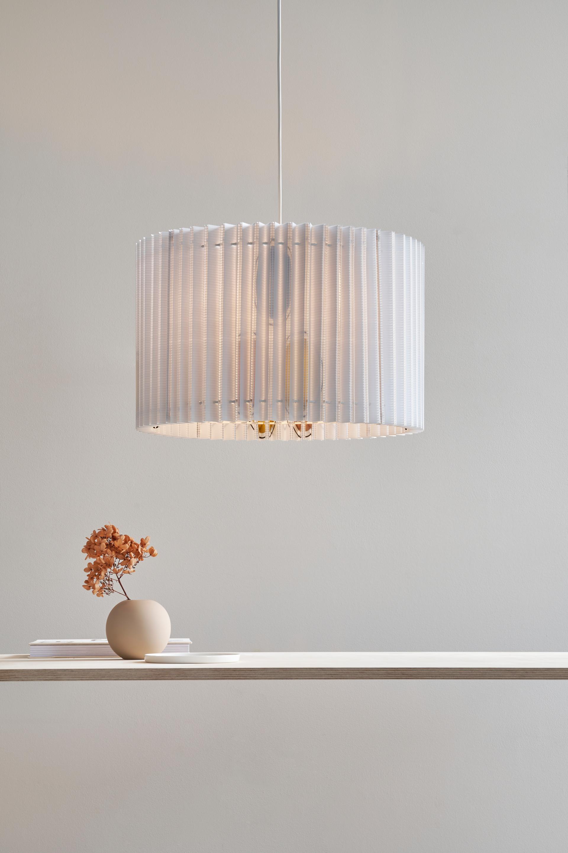 Sustainable sculptural lampshade from Tabitha Bargh's Poly collection, elegantly displayed with decorative vase and books.