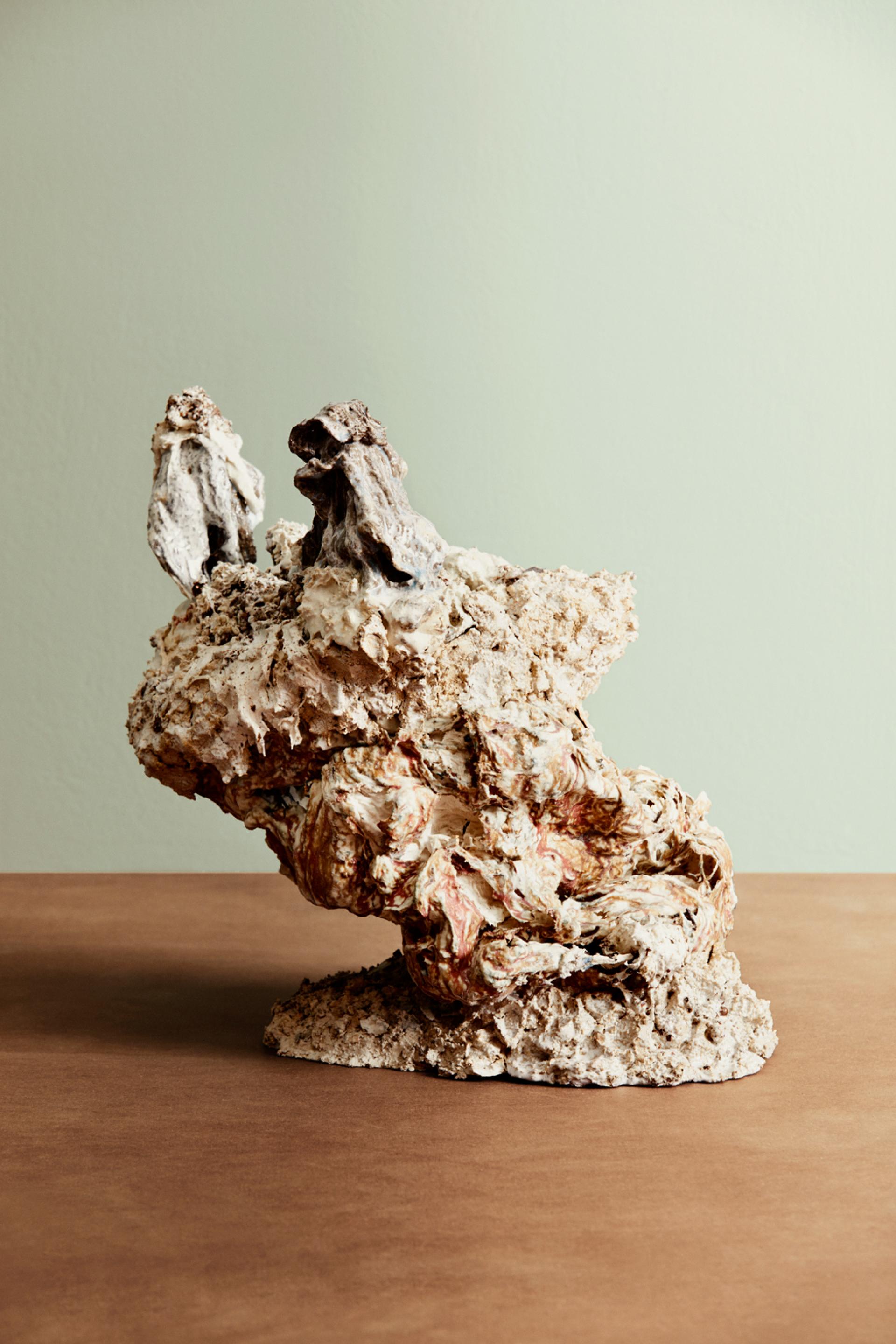 Sculptural piece resembling organic forms, highlighting community and sustainability themes, displayed on a wooden table.