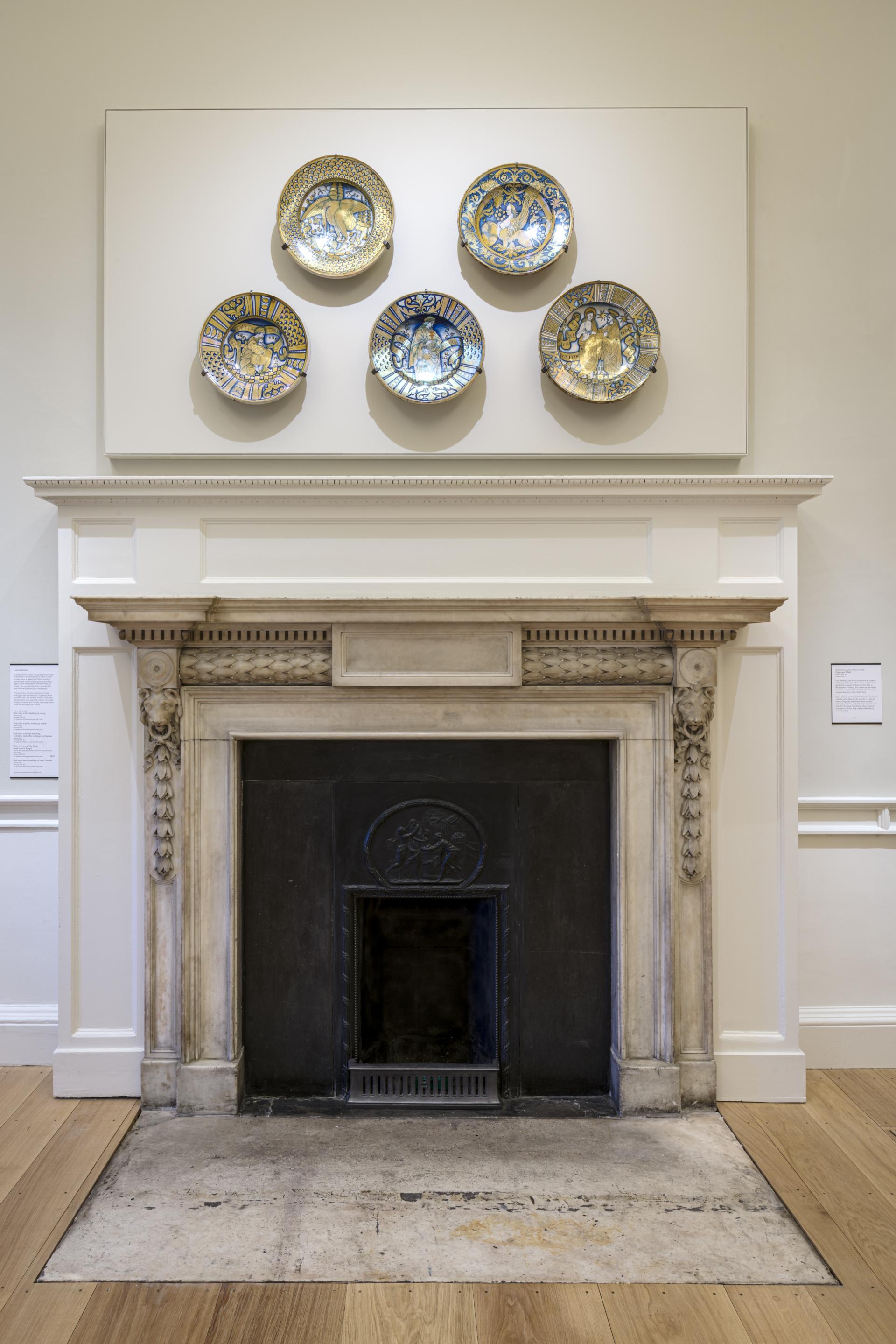 Ceramic plates displayed above an elegant fireplace, showcasing art in The Courtauld Gallery's redesigned visitor space.
