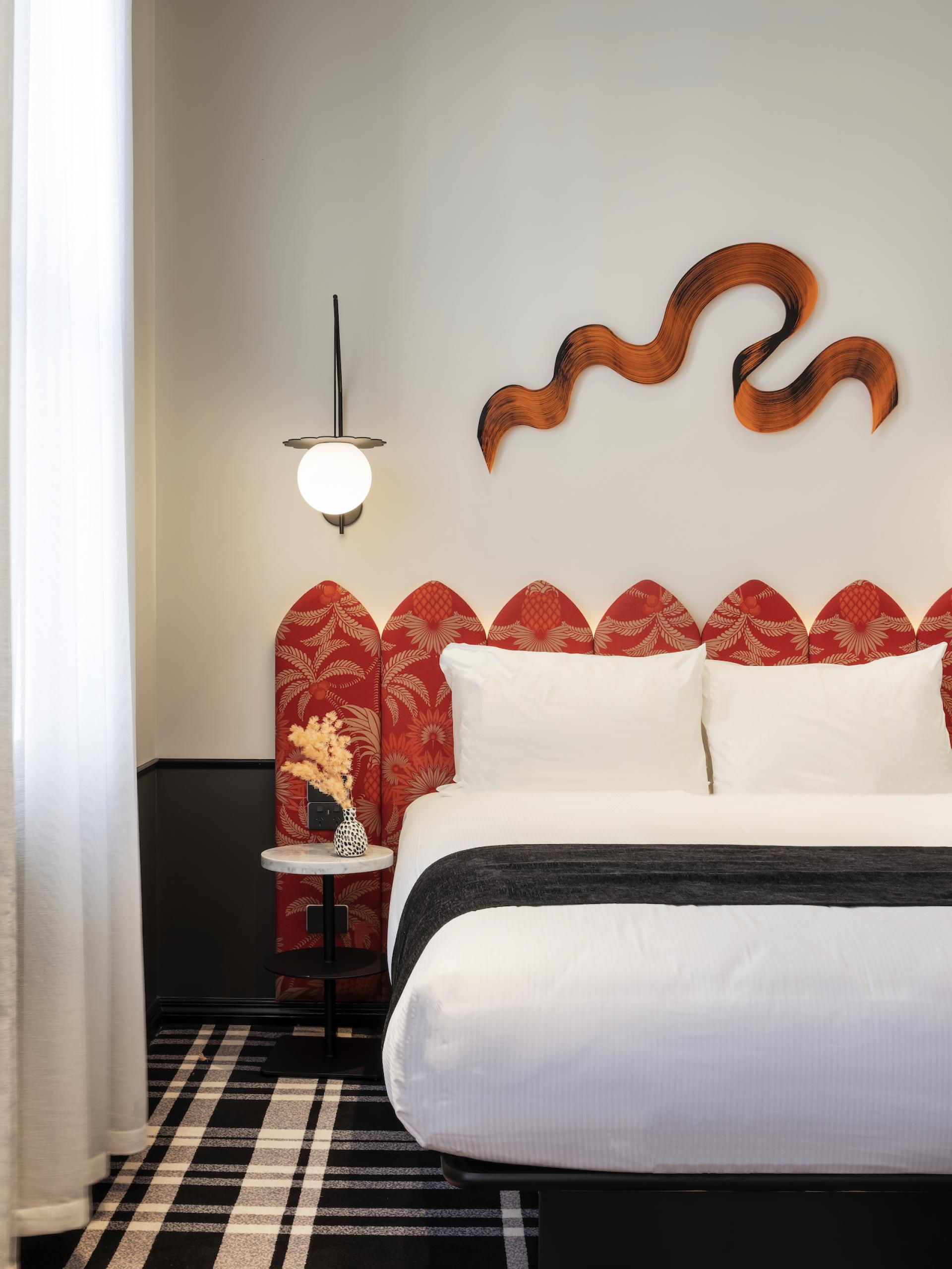 Vibrant hotel room featuring bold colour blocking, intricate decor, and modern botanical accents at Naumi Studio Hotel, Wellington.